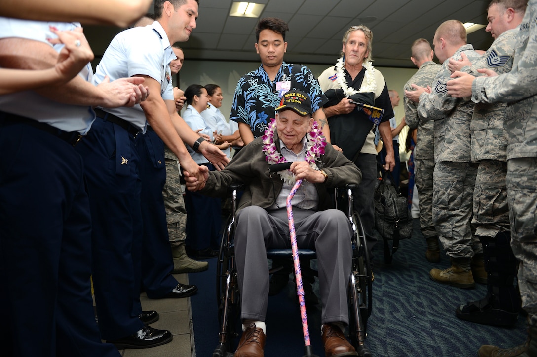 A World War II veteran shakes hands with service members at the Honolulu International Airport, Dec. 3, 2016. Coast Guard photo by Petty Officer 2nd Class Tara Molle