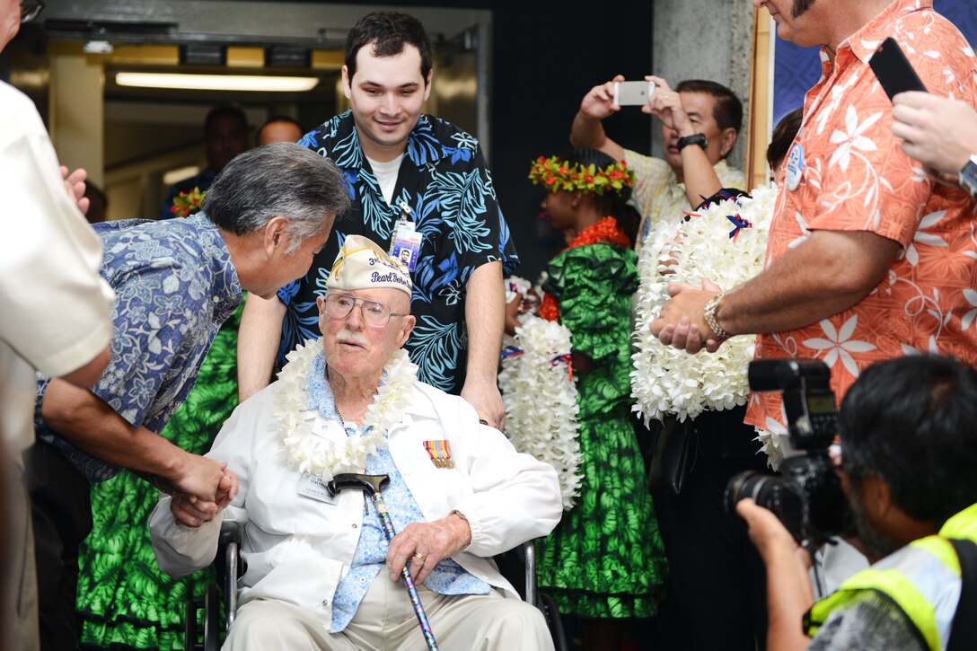 Hawaii State Governor David Y. Ige, left, shakes the hand of a Pearl Harbor survivor at the Honolulu International Airport, Dec. 3, 2016. Coast Guard photo by Petty Officer 2nd Class Tara Molle