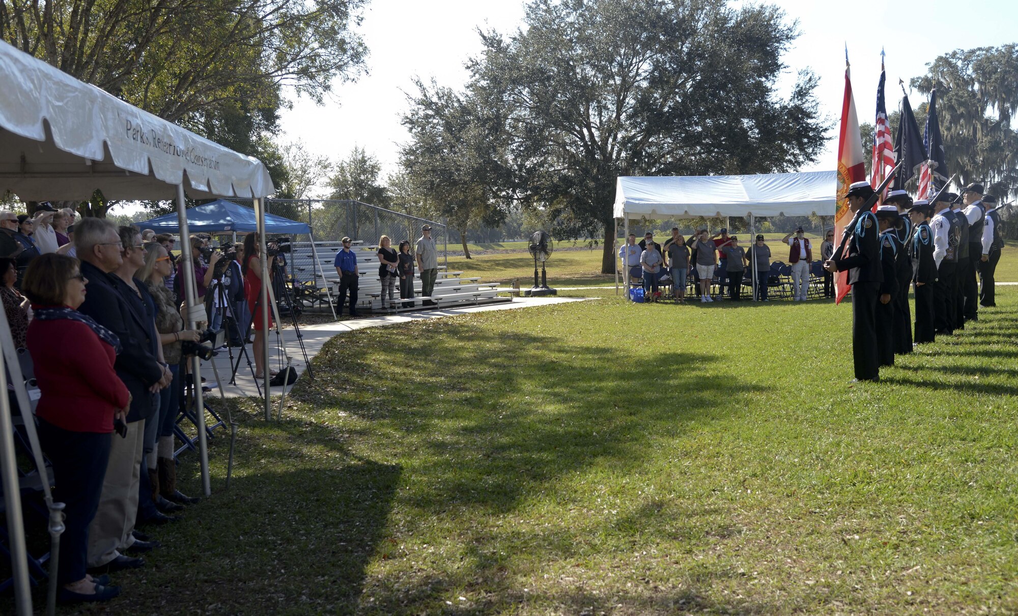 Audience members observe a colors presentation during the Pearl Harbor Remembrance Day ceremony at Veterans Memorial Park in Tampa, Fla., Dec. 7, 2016. Attendees observed various 75th anniversary tributes to include MacDill Air Force Base, Fla., a flag presentation and memorial wreath ceremony. (U.S. Air Force photo by Senior Airman Vernon L. Fowler Jr.)