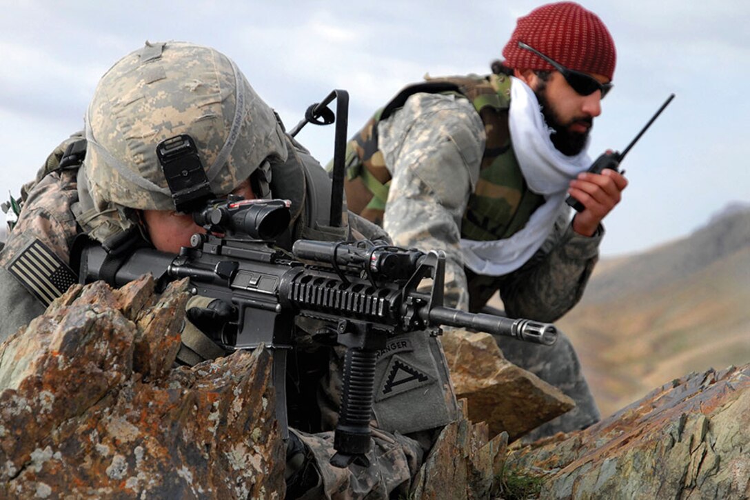 1st Lt. Jared Tomberlin, left, and an interpreter pull security on top of a mountain ridge during a reconnaissance mission near Forward Operating Base Lane in the Zabul province of Afghanistan.