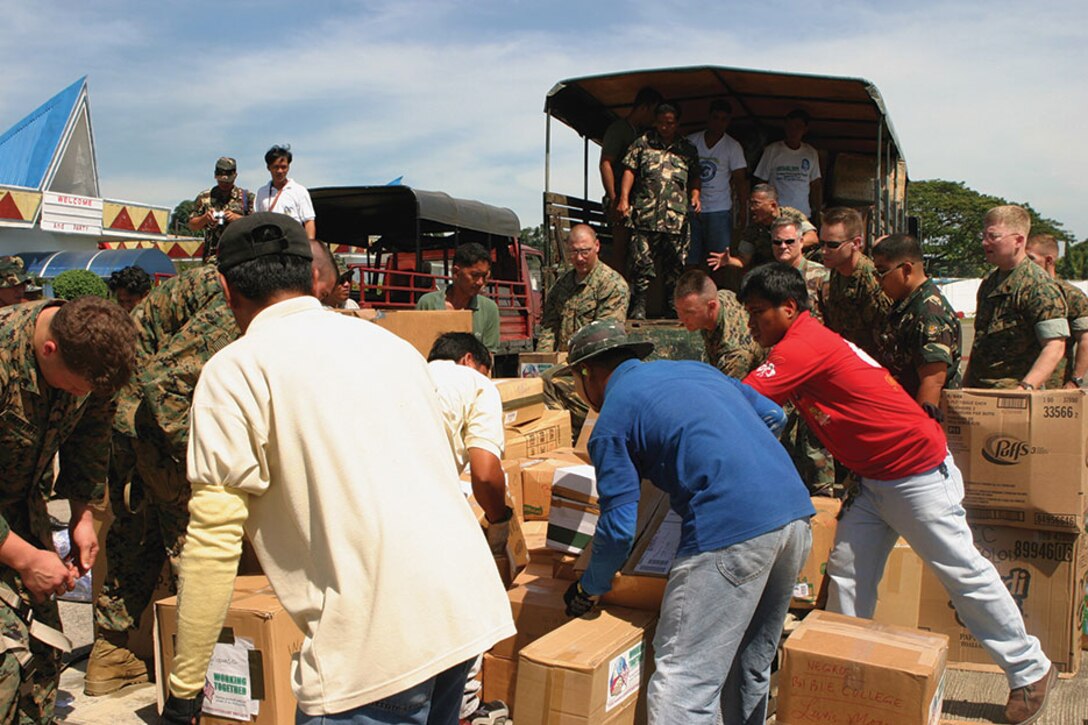 U.S. Marines, local residents and Philippine army soldiers work together to unload supplies in Operation Goodwill Delivery.