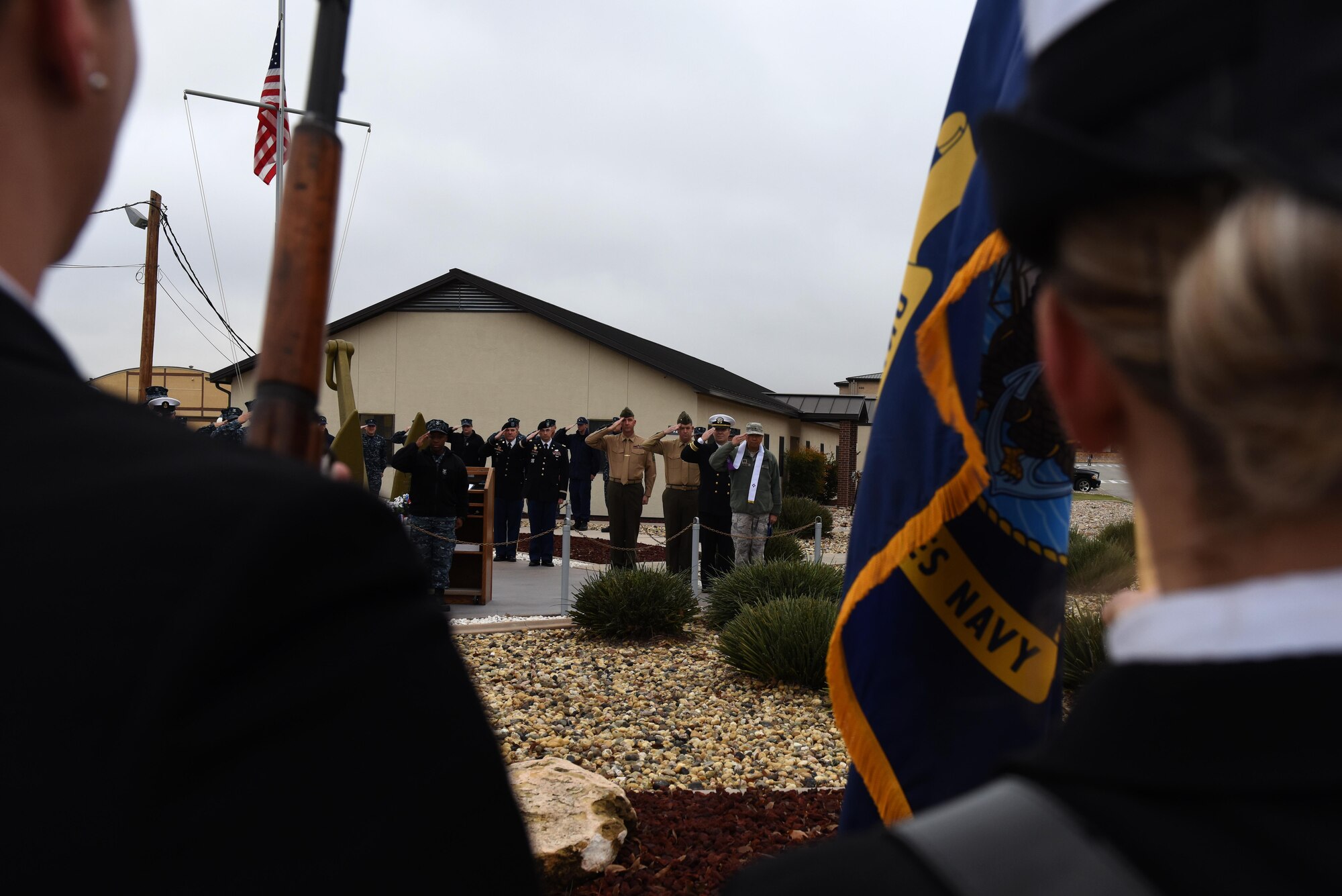 Sailors, Soldiers and Marines salute during presenting colors for the 75th Pearl Harbor remembrance ceremony at Liberty Park on Goodfellow Air Force Base, Texas, Dec. 7, 2016. Representatives from the different branches involved with Pearl Harbor came to the ceremony. (U.S. Air Force photo by Airman 1st Class Caelynn Ferguson/Released)