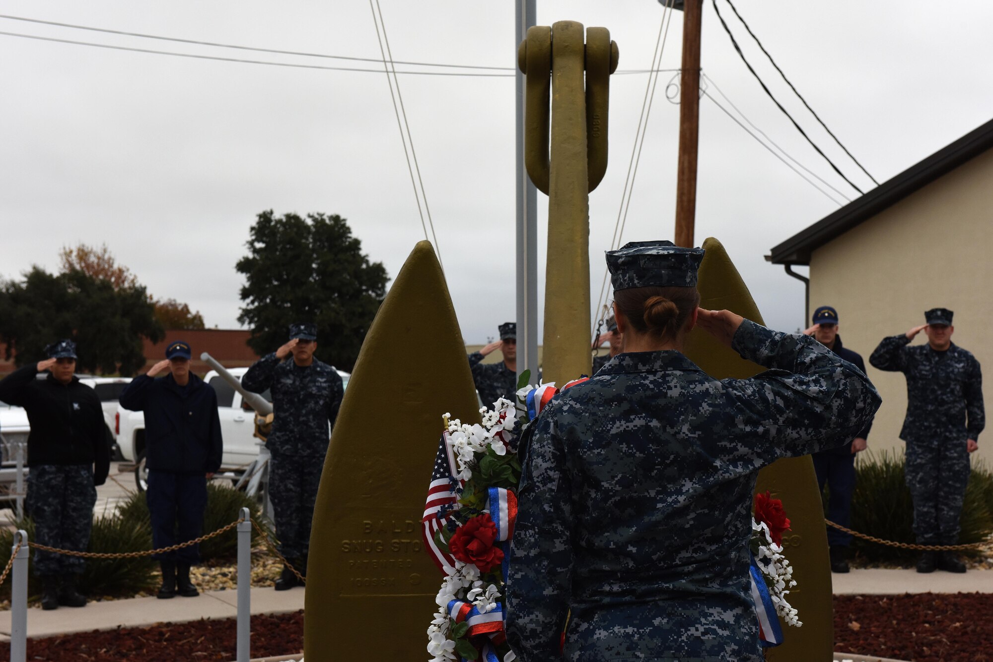 U.S. Navy sailors salute a memorial wreath during Taps for the 75th Pearl Harbor remembrance ceremony at Liberty Park on Goodfellow Air Force Base, Texas, Dec. 7, 2016. The wreath was placed out in the open for base members to observe. (U.S. Air Force photo by Airman 1st Class Caelynn Ferguson/Released)