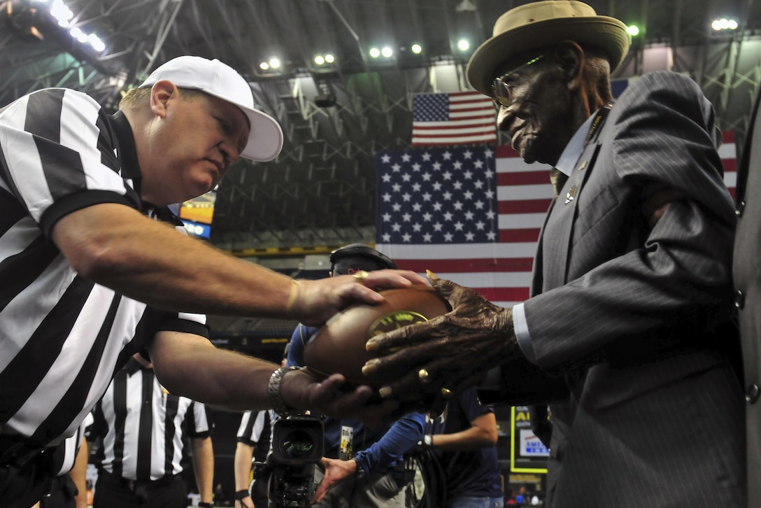 Richard Overton, right, one of the oldest-living World War II veterans, passed the game ball to the referees before the 2016 All-American Bowl in San Antonio, Jan. 9, 2016. Overton served with the 1887th Aviation Engineer Battalion. U.S. Army Photo by Sgt. Bethany L. Huff