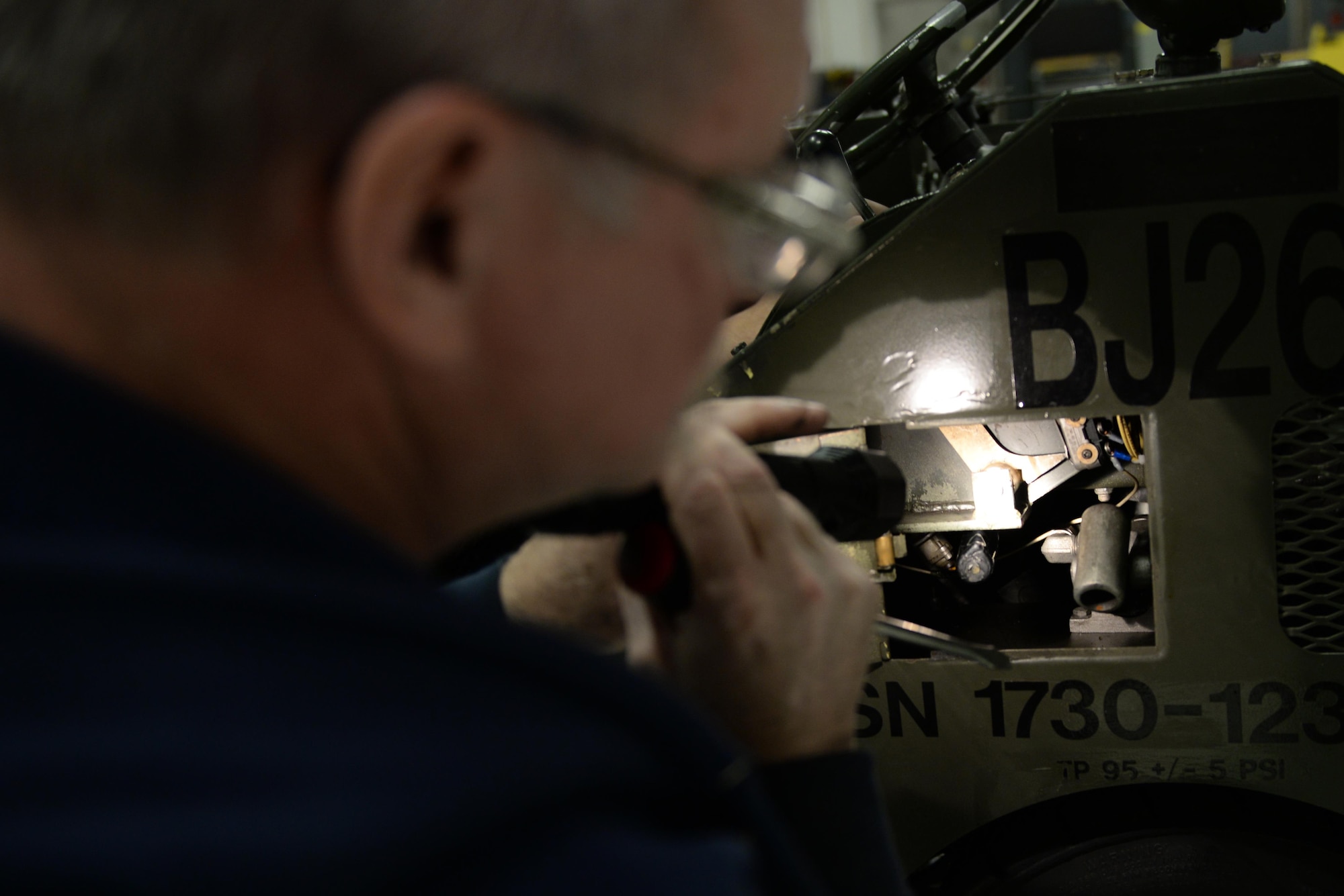 Department of the Air Force Robert Wurster, a 354th Maintenance Squadron aerospace ground equipment technician, inspects a MJ-1 bomb lift Dec. 5, 2016, at Eielson Air Force Base, Alaska. Wurster found and replaced a broken fuse which allowed the lift to continue operations. (U.S. Air Force photo by Airman Eric M. Fisher)