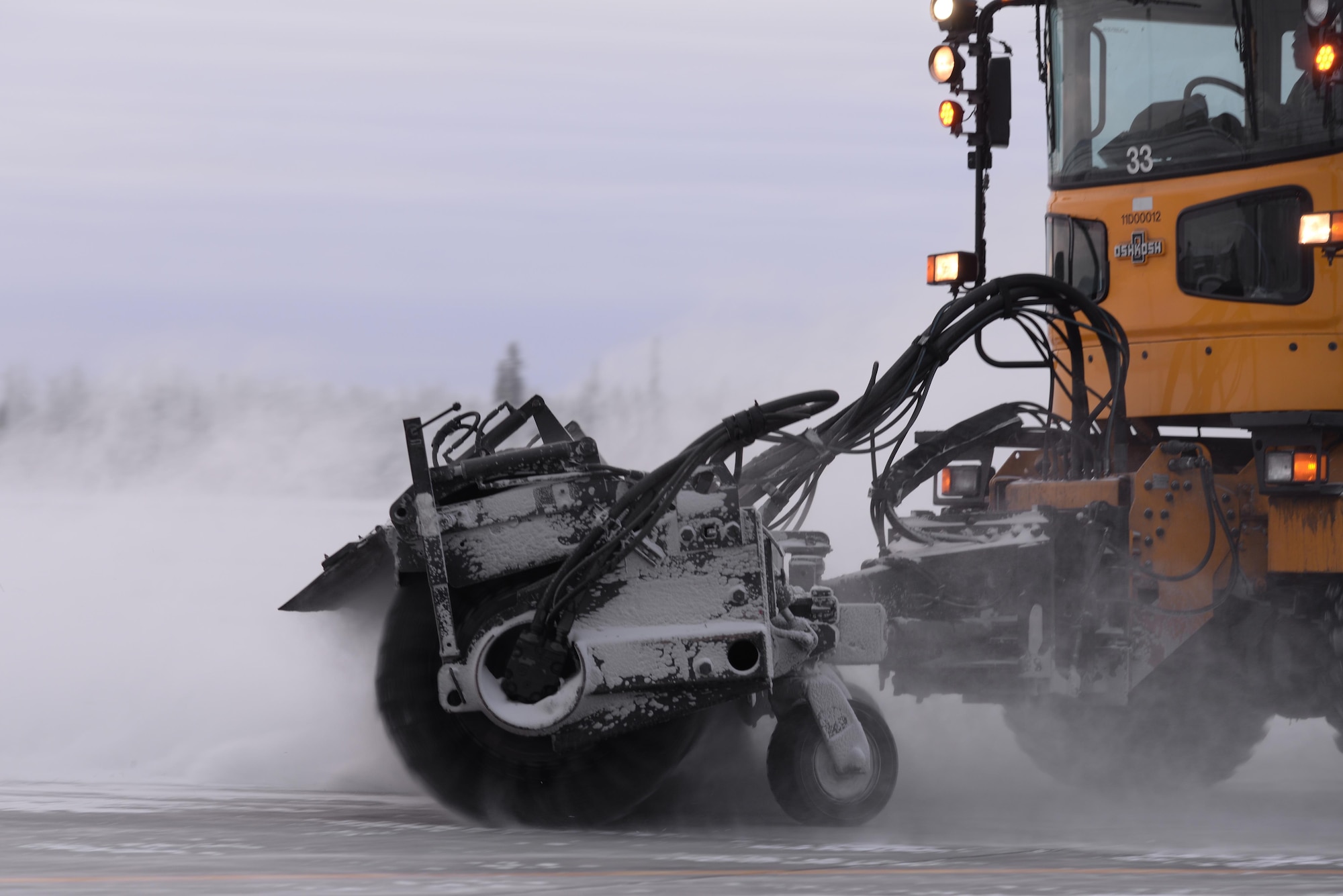 U.S. Air Force Airman Austin Oliver, a 354th Civil Engineer Squadron pavement and construction equipment operator, drives a snow broom to clear part of the flight line Dec. 1, 2016, at Eielson Air Force Base, Alaska. Eielson's Snow Barn clears snow and ice off the flight line to allow for continued operations. (U.S. Air Force photo by Airman Eric M. Fisher)
