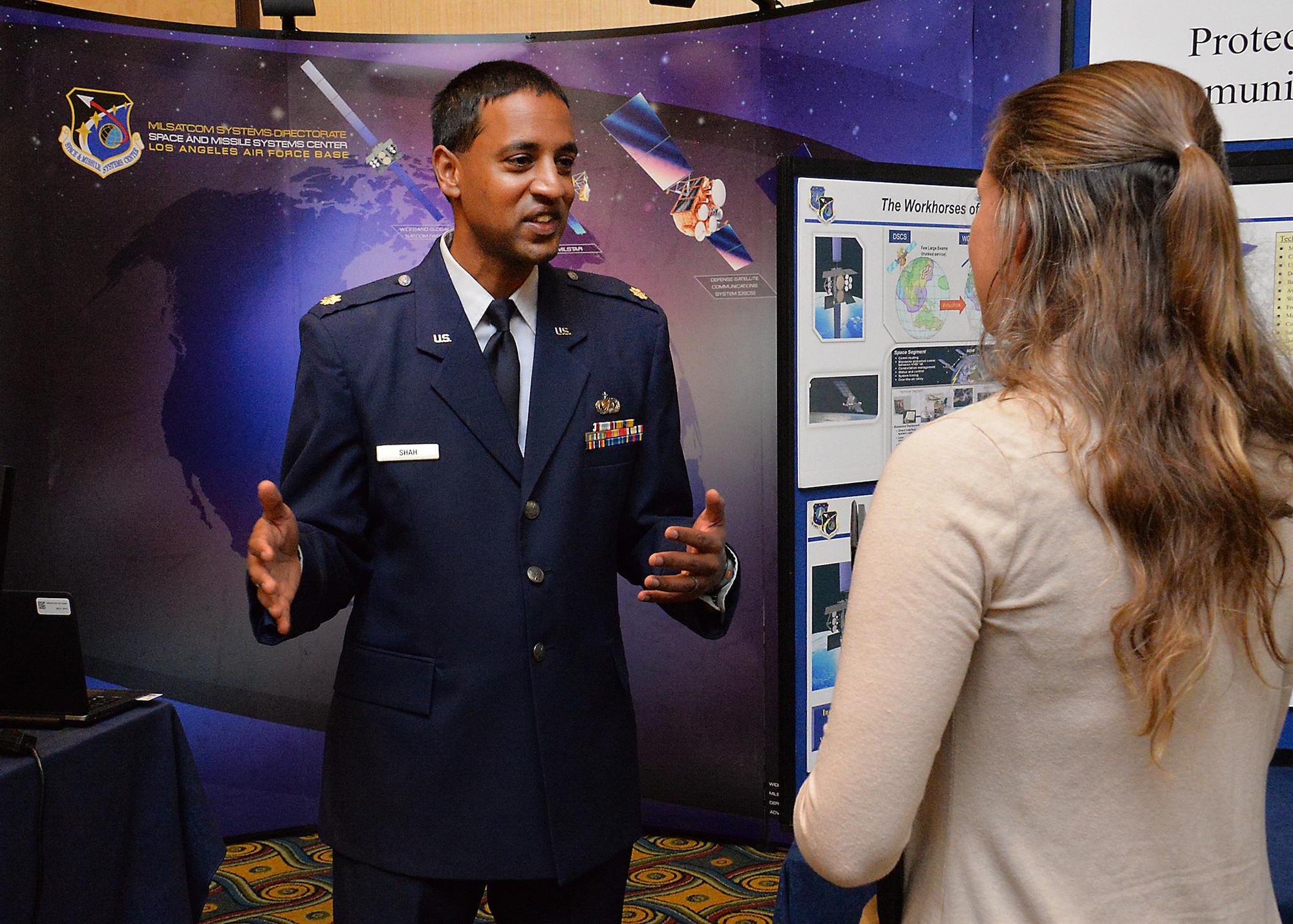 Maj. Anand Shah, deputy of the Advanced Extremely High Frequency space segment branch in SMC’s Military Satellite Communications Directorate, discusses details of the MILSATCOM program with a prospective applicant during an Air Force Civilian Service Job Fair Nov. 16 at the Los Angeles Airport Marriott. The one-day job fair was hosted by Personnel from the Space and Missile Systems Center and Air Force Personnel Center.