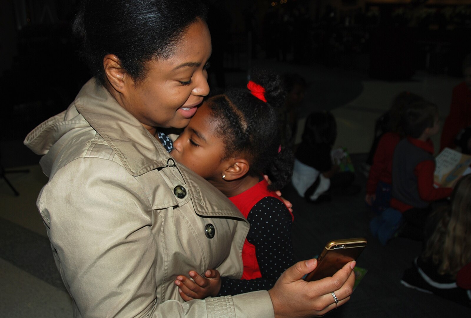 Akera Gamble embraces her daughter, Arielle, during a Facetime chat with her husband minutes before Arielle sings for attendees Dec. 7 at the annual McNamara Headquarters Complex tree lighting ceremony. 