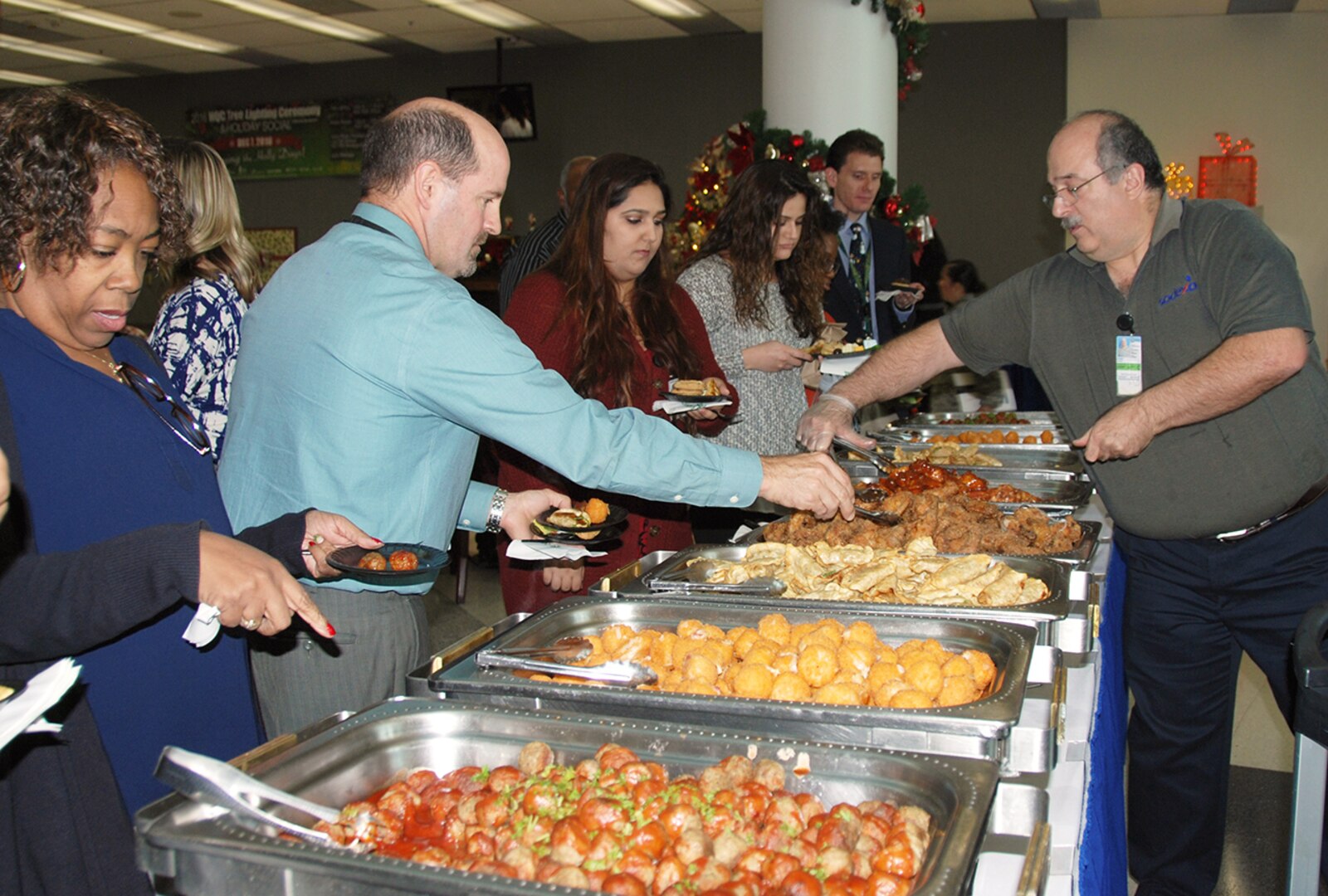 McNamara Headquarters Complex employees help themselves to free snacks at a holiday social following the annual HQC tree lighting ceremony Dec. 7.