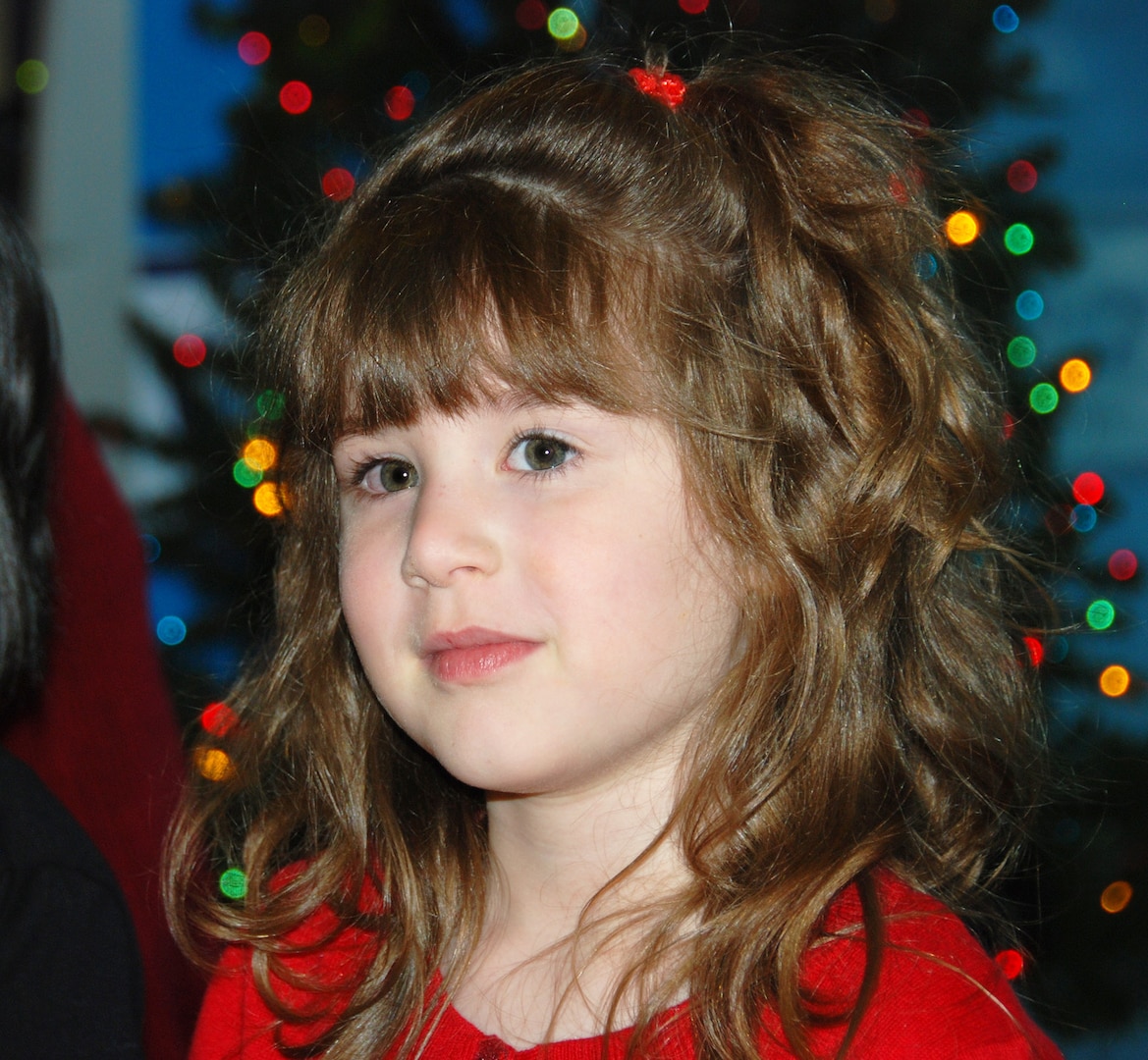 Four-year-old Mary Baker pauses while shyly singing “Santa Claus is Coming to Town” Dec. 7 at the McNamara Headquarters Complex. She and the rest of the HQC Child Development Center’s pre-kindergarten class sang songs for those gathered at the annual HQC tree lighting ceremony. 