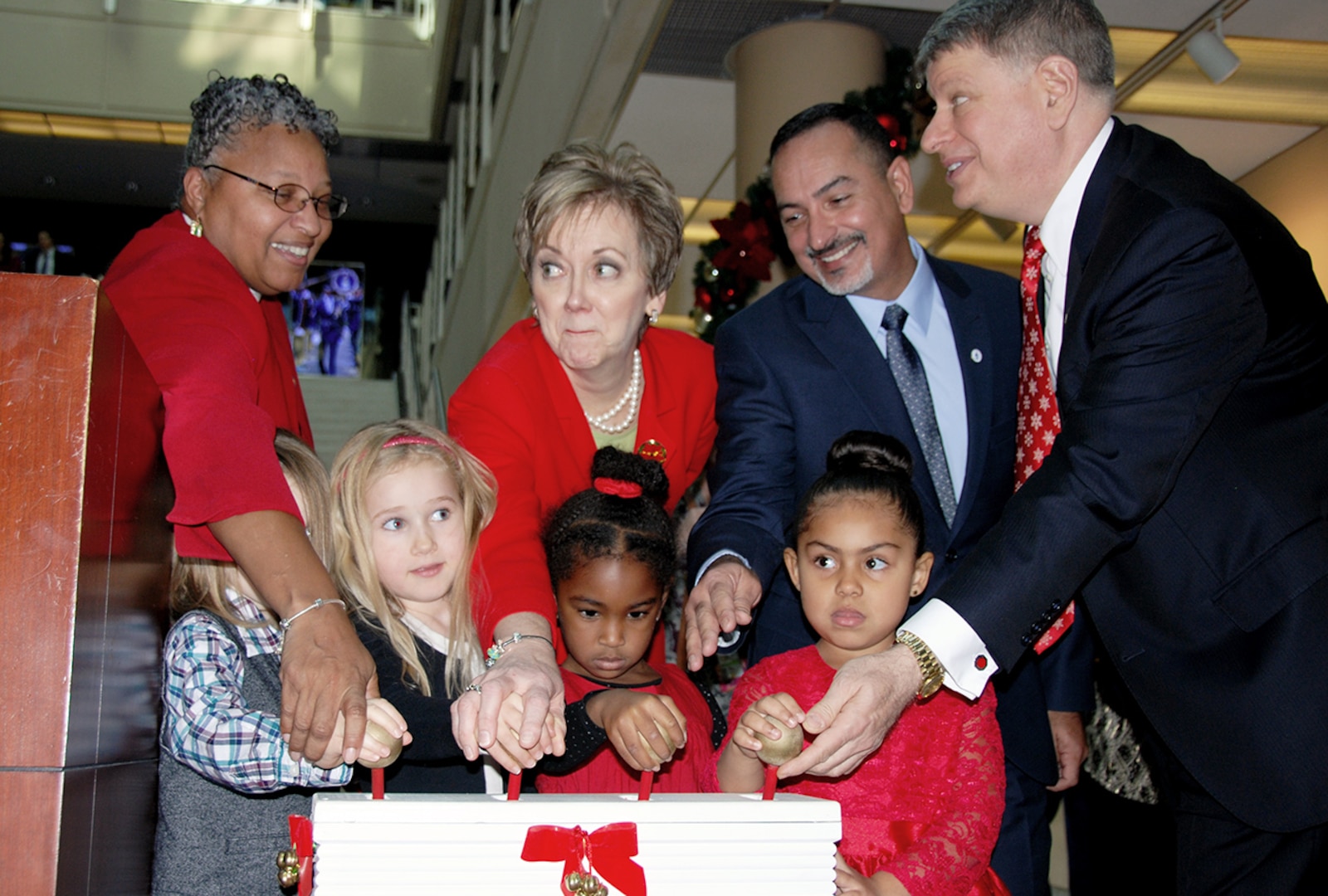 Senior leaders of agencies residing in the McNamara Headquarters Complex flip switches lighting up the building’s official Christmas tree with help from children enrolled in the HQC Child Development Center’s pre-kindergarten class.