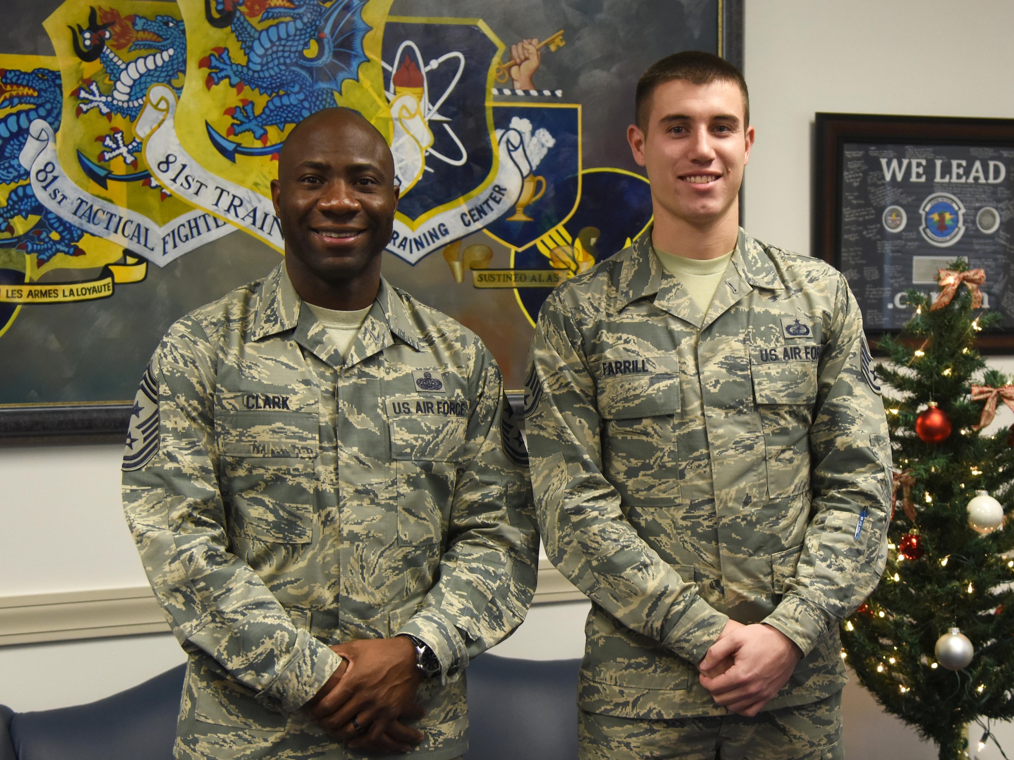 Chief Master Sgt. Vegas Clark, 81st Training Wing command chief, and Staff Sgt. Aaron Farrill, 81st Contracting Squadron unit training manager, pose for a photo at the 81st TRW headquarters building Dec. 7, 2016, at Keesler Air Force Base, Miss. Farrill participated in the new Command Chief for a Day program which highlights outstanding enlisted performers from around the wing. Each Airman selected for the program will spend the day shadowing Clark to learn what it takes to be a command chief. (U.S. Air Force photo by Kemberly Groue)