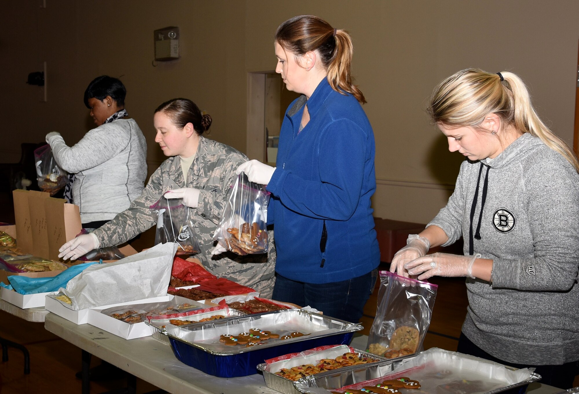 Team BLAZE volunteers bag cookies donated by the base populace in the youth center Dec. 5 at Columbus Air Force Base, Mississippi. The cookies were bagged and given to Airmen residing in the dormitories as part of the Airman Holiday Cookie Drive. (U.S. Air Force photo by Elizabeth Owens)