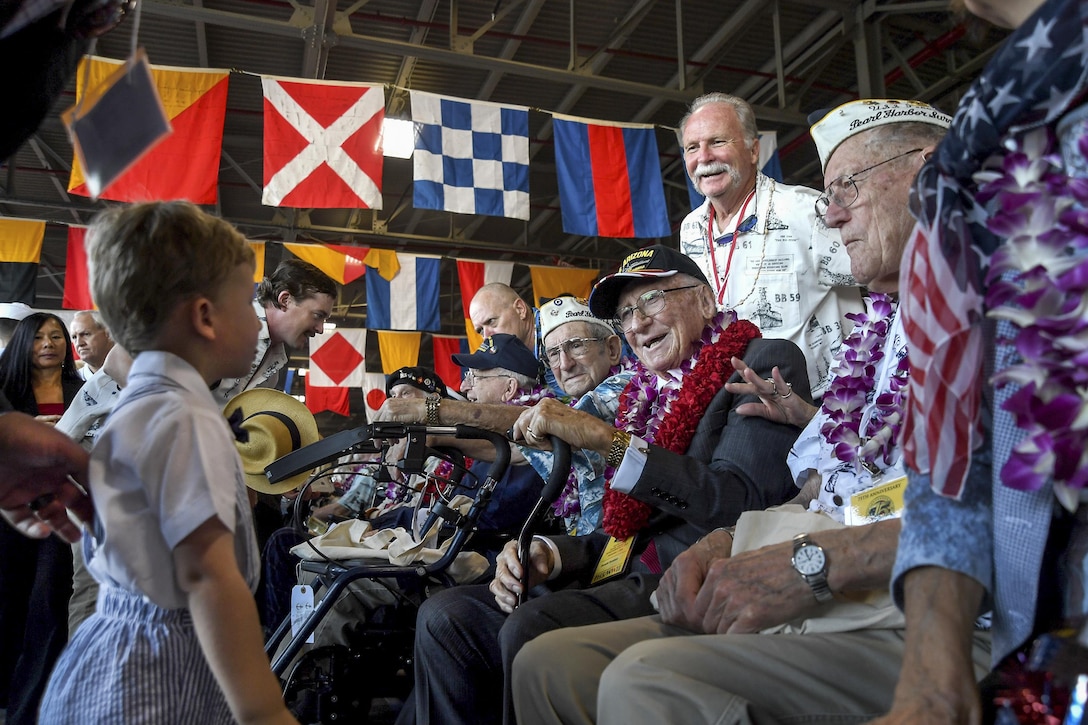 Pearl Harbor survivors greet a child during the 75th commemoration of the attacks on Pearl Harbor at Pearl Harbor, Hawaii, Dec. 7, 2016. The U.S. military co-hosted the event, which provided veterans, family members, service members and the community a chance to honor the sacrifices made by those who were present during the attacks. Navy photo by Petty Officer 2nd Class Laurie Dexter