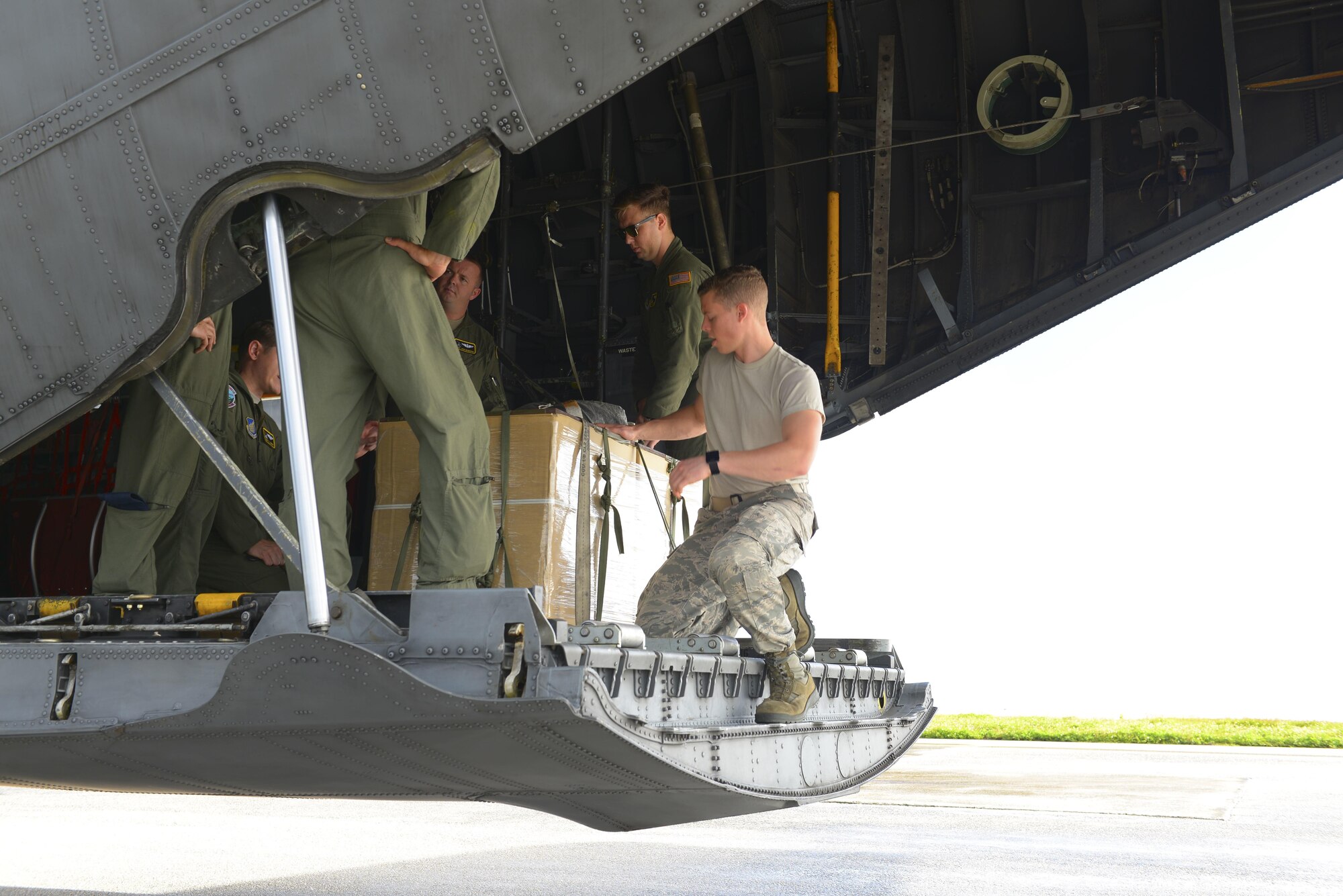Air crew and maintenance personnel assigned to Yokota Air Base prepare a humanitarian aid bundle aboard a C-130 H at Andersen Air Force Base, Guam, Dec. 5, 2016. The bundle was part of Operation Christmas Drop, an event held each year for 65 years, dropping donated supplies and gifts to islanders in Micronesia. (U.S. Air Force photo by Senior Airman Elizabeth Baker/Released)