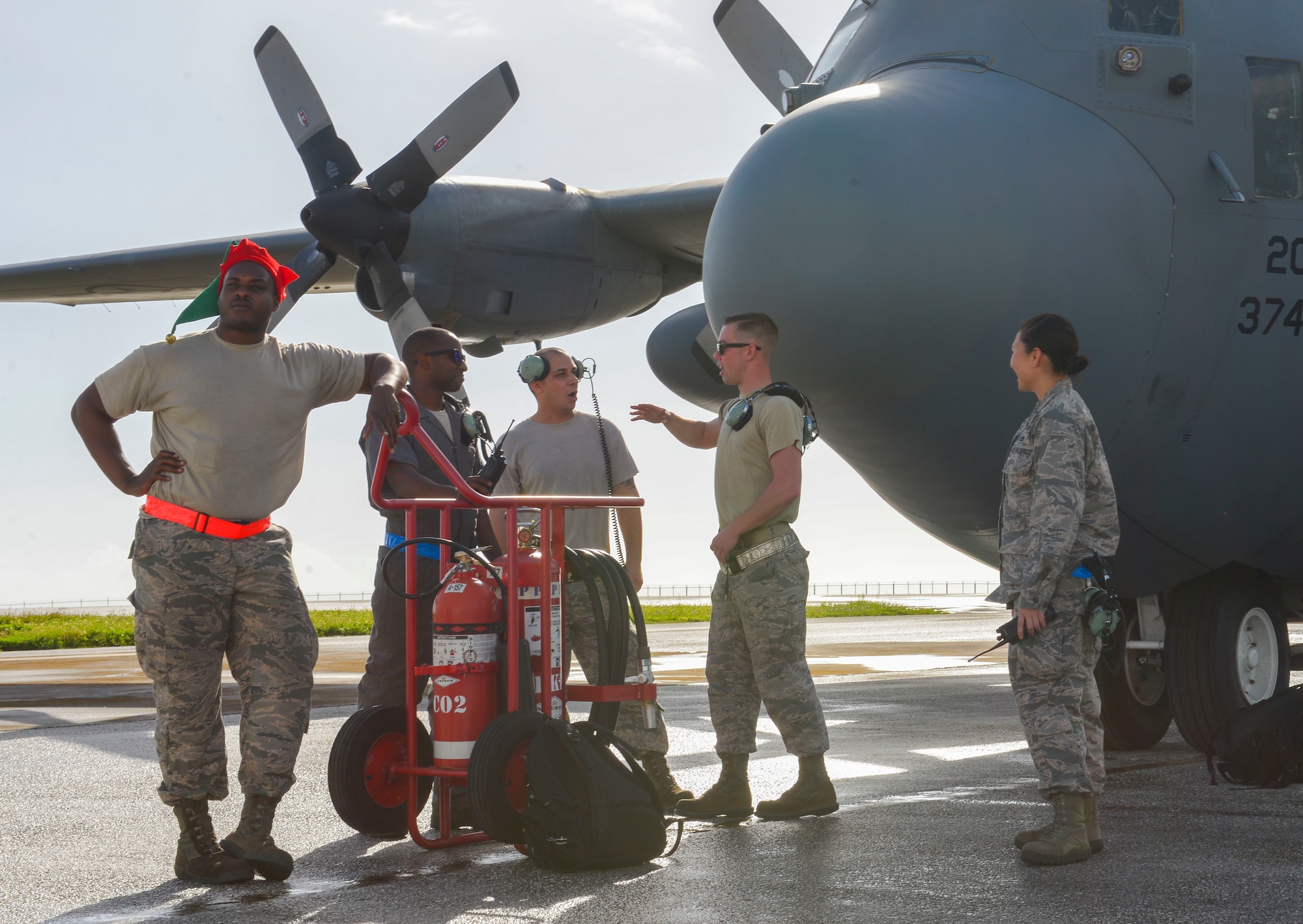 Maintenance personnel participating in Operation Christmas Drop await engine start in front of a C-130 H at Andersen Air Force Base, Guam, Dec. 5, 2016. The C-130 performed a practice bundle drop in preparation for upcoming bundle drops over the Micronesian Islands. Each year OCD provides aid to over 30,000 islanders in Chuuk, Palau, Yap, Marshall Islands and Commonwealth of the Northern Mariana Islands. (U.S. Air Force photo by Senior Airman Elizabeth Baker/Released)