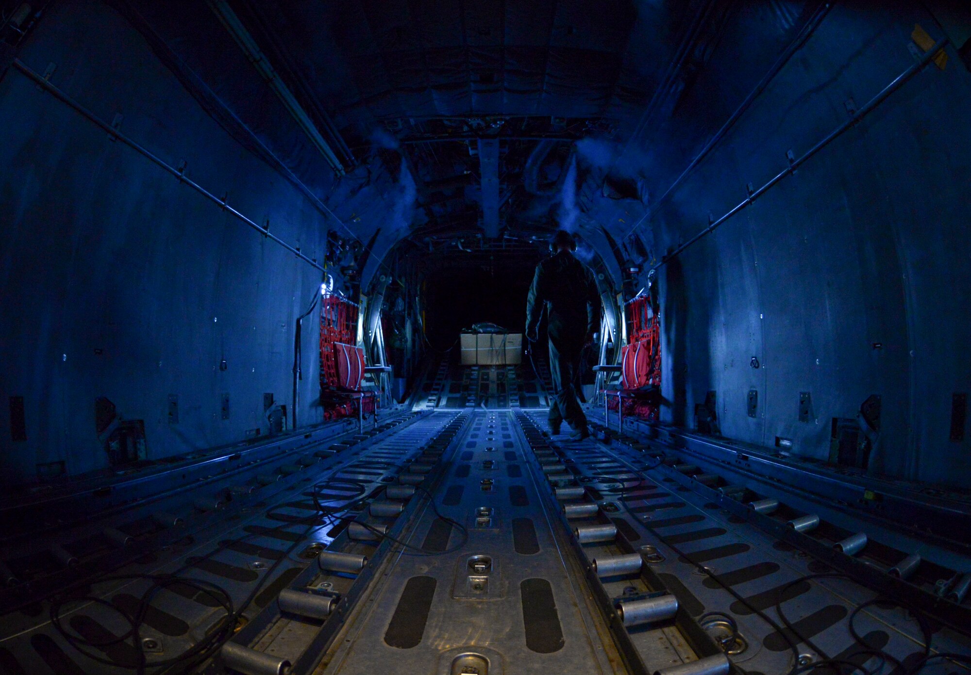 Staff Sgt. Timothy Johnson, 36th Airlift Squadron loadmaster, walks the cargo hold of a C-130 H flying over the Micronesian Islands Dec. 5, 2016. Johnson participated in Operation Christmas Drop, an event held each year for 65 years, dropping donated supplies and gifts to islanders in Micronesia. (U.S. Air Force photo by Senior Airman Elizabeth Baker/Released)