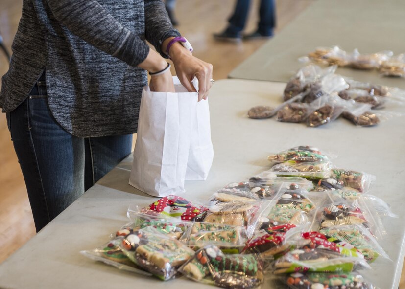 A volunteer places a bag of decorated cut-out cookies into a package for the Airman Cookie Drive at the Community Activity Center at Holloman Air Force Base, N.M. on Dec. 4, 2016. Holloman’s annual Airman Cookie Drive collects and distributes donated cookies to Airmen living in the base dorms during the holiday season. (U.S. Air Force photo by Airman 1st Class Alexis P. Docherty) 