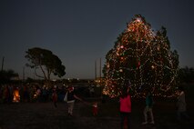 Members of Laughlin Air Force Base gather around the newly lit Christmas tree here Nov. 30, 2016. The base Christmas tree lighting kicks off the holiday season with caroling, hot cocoa and cookies.  (U.S. Air Force photo/Airman 1st Class Benjamin N. Valmoja)