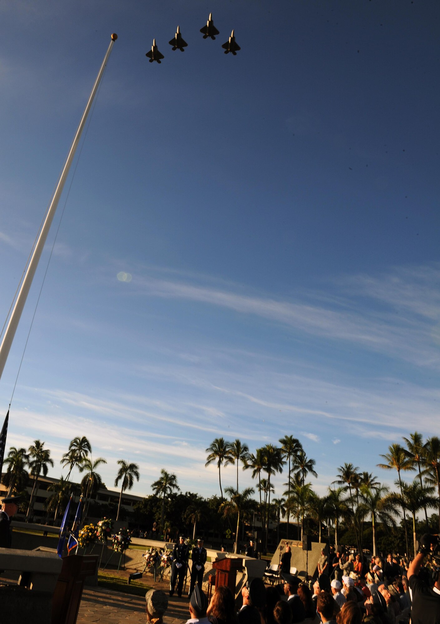 A formation of F-22 Raptors perform a flyover above the 75th Commemoration of the Dec. 7, 1941 attack on Hickam Field ceremony Dec. 7, 2016, at Joint Base Pearl Harbor-Hickam, Hawaii. The attacks on seven bases throughout Oahu precipitated America's entry into World War II, and the annual commemoration ceremony is designed to foster reflection, remembrance, and understanding for those affected by the events that took place 75 years ago. (U.S. Air Force photo by Tech. Sgt. Nathan Allen)