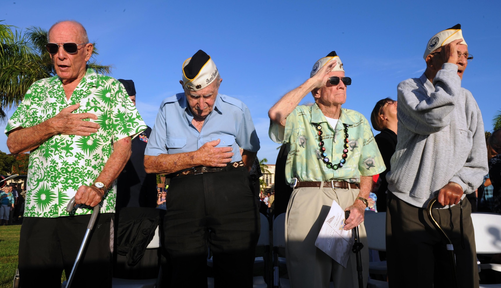 Survivors of the attacks on Pearl Harbor Naval Station and Hickam Field stand during the singing of the national anthem during the 75th Commemoration of the Dec. 7, 1941 attack on Hickam Field ceremony  Dec. 7, 2016, at Joint Base Pearl Harbor-Hickam, Hawaii. The attacks on seven bases throughout Oahu precipitated America's entry into World War II, and the annual commemoration ceremony is designed to foster reflection, remembrance, and understanding for those affected by the events that took place 75 years ago. (U.S. Air Force photo by Tech. Sgt. Nathan Allen)