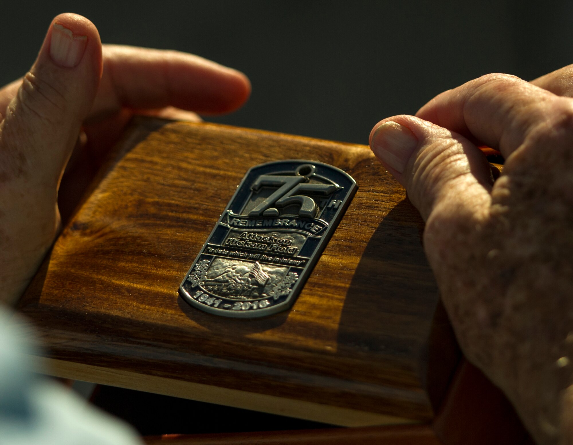 U.S. Army Private Edward Bloch, a survivor of the attack on Hickam Field, holds a wooden box given to him during the 75th Commemoration of the Dec. 7, 1941 attack on Hickam Field ceremony Dec. 7, 2016, at Joint Base Pearl Harbor-Hickam, Hawaii. Bloch was a switchboard operator in the control tower assigned to the 5th Bomb Group at Hickam Field. During the attack, he made eye contact with a Japanese aircraft gunner and recalls the Star Spangled Banner being played over the public announcement system between the two waves of attacks. After the attack, Bloch served in the South Pacific Flying Combat crew in the B-17 Flying Fortress and B-24 Liberator Bombers. (U.S. Air Force photo by Tech. Sgt. Nathan Allen)