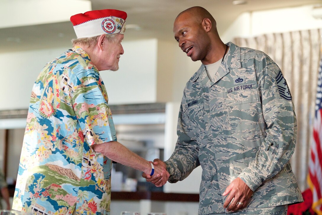 U.S. Air Force Chief Master Sgt. Jerry Williams, 15th Wing command chief, greets Mr. Virgil Henderson, a Dec. 7 attacks survivor, during a dinner on Dec. 6, 2016, Joint Base Pearl Harbor-Hickam, Hawaii. The dinner was part of a week long celebration commemorating the 75th anniversary of the attacks on Pearl Harbor, Hickam Field and Oahu. The U.S. military and the State of Hawaii are hosting a series of remembrance events to honor the Pacific Theater's veterans. (U.S. Air Force photo by Tech. Sgt. James Stewart/Released)