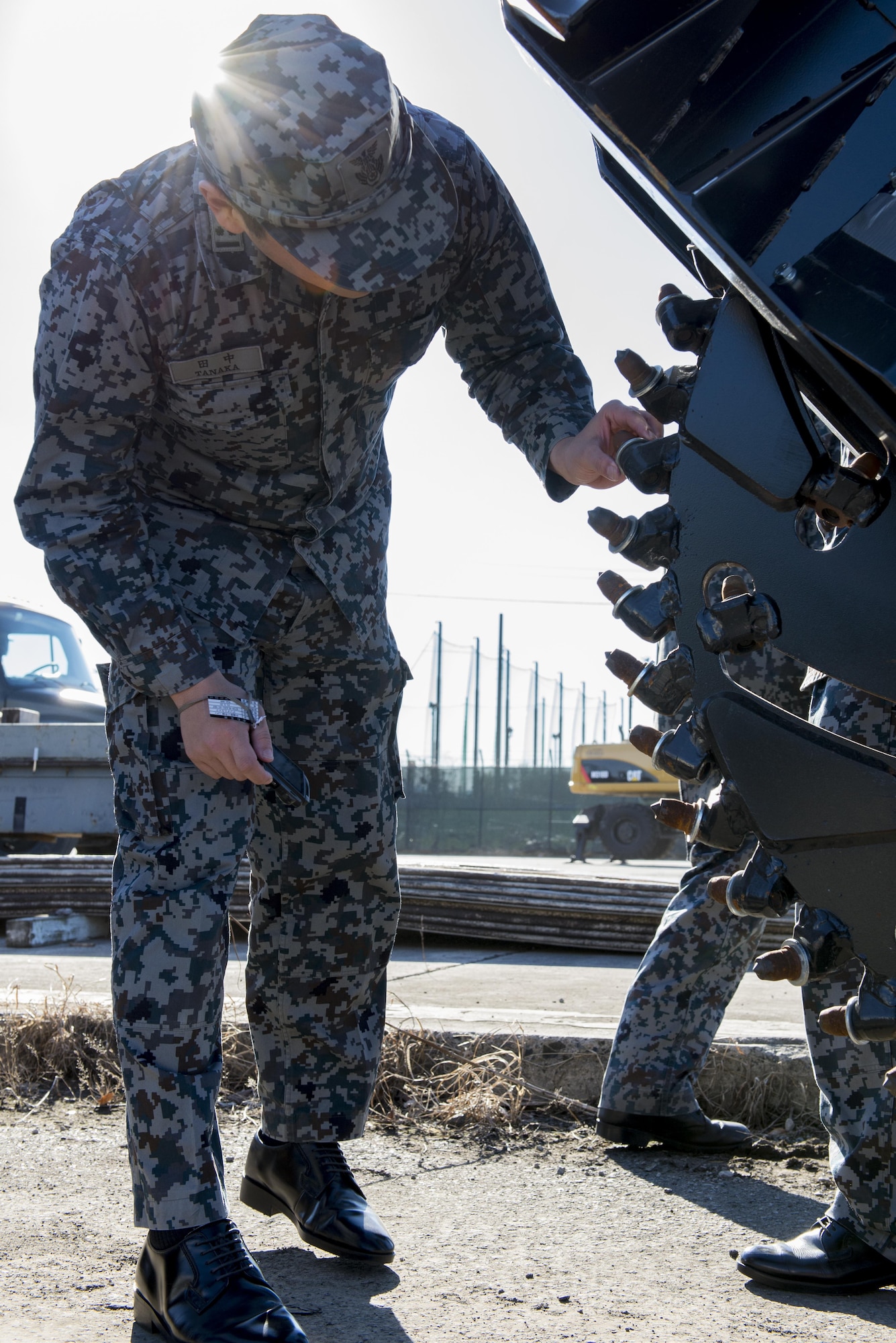 A Japan Air Self Defense Force member inspects a piece of machinery during a 374th Civil Engineering Squadrons Rapid Airfield Damage Repair demonstration Dec. 6, 2016, at Yokota Air Base, Japan. The purpose of the RADR demonstration is to share capabilities and techniques with JASDF members in the event of an airfield attack and to promote bilateral engagement between the U.S. and Japan. (U.S. Air Force photo by Airman 1st Class Donald Hudson/Released)
