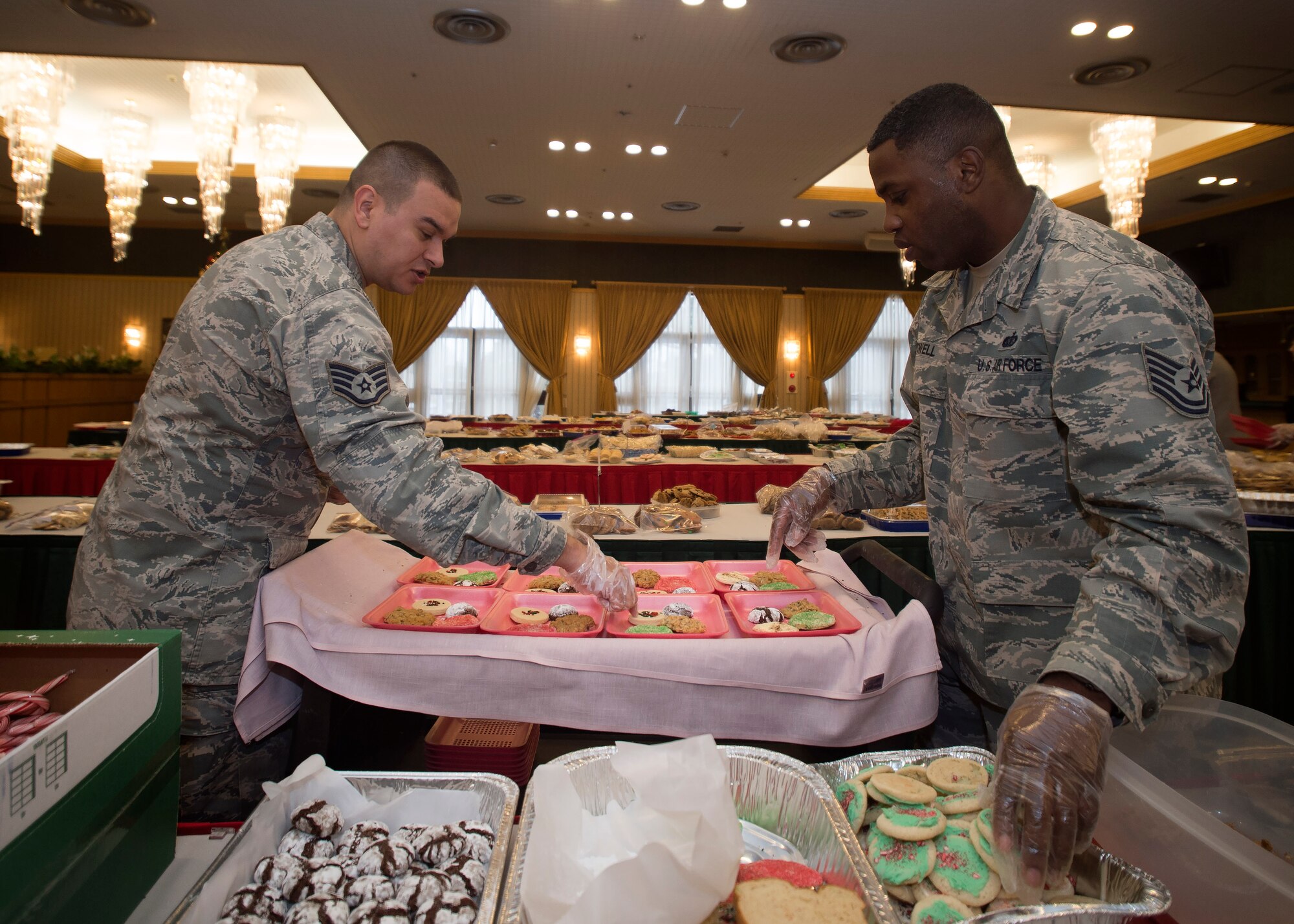 U.S. Air Force Staff Sgt. Robert Smalling, left, the 35th Medial Operations Squadron immunizations NCO in charge, and Tech. Sgt. Johnnie Powell, right, the 35th Force Support Squadron readiness and mortuary affairs NCO in charge, divide cookies during the annual Cookie Caper event at Misawa Air Base, Japan, Dec. 7, 2016. Volunteers gave more than 14,400 home-baked cookies to the event, while others donated dough to be cooked. (U.S. Air Force photo by Senior Airman Deana Heitzman)