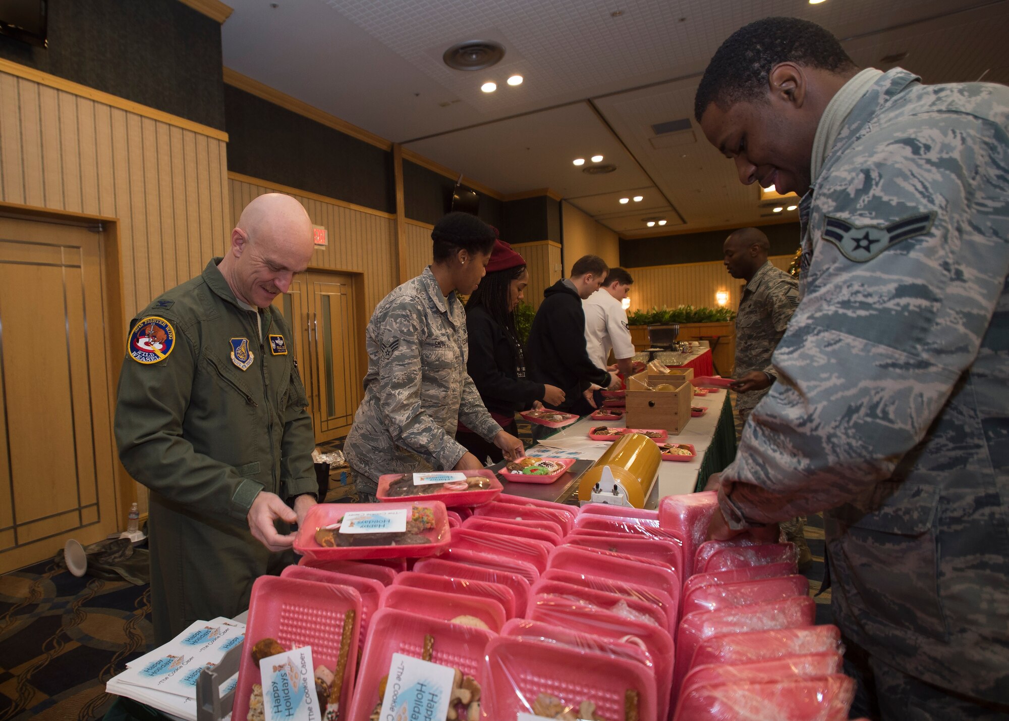 U.S. Air Force Col. R. Scott Jobe, 35th Fighter Wing commander, assists Airmen package cookies during the annual Cookie Caper event at Misawa Air Base, Japan, Dec. 7, 2016.  Preparation began two days prior when volunteers baked donated dough at the Commissary and collected baked cookies from around the Misawa community for packaging. (U.S. Air Force photo by Senior Airman Deana Heitzman)