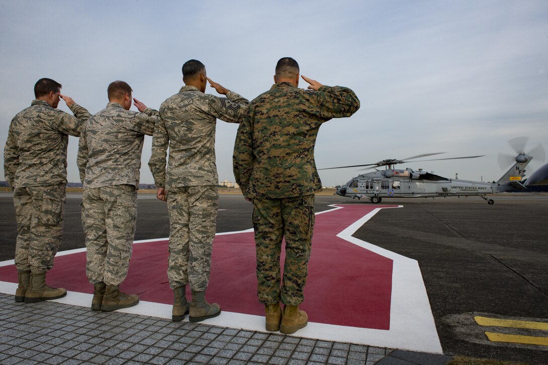 The departure party salutes U.S. Secretary of Defense Ashton B. Carter preparing to take off in HH-60H Seahawk on Dec. 5, 2016 at Yokota Air Base, Japan. Carter stopped at Yokota during his travel to U.S. military instillations across the world, with plans to thank deployed U.S. troops for their service over the holidays. (U.S. Air Force photo by Airman 1st Class Donald Hudson/Released)