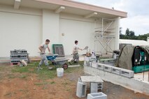 U.S. Air Force Airman 1st Class Daniel Davis and Michael Gutenberger, 18th Civil Engineer Squadron structural apprentices, prepare mortar for brick-laying Dec. 7, 2016, at Kadena Air Base, Japan. Back-up generators are a necessity for every building. Constructing brick walls protects them from the elements. (U.S. Air Force photo by Senior Airman Lynette M. Rolen/Released)