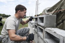 U.S. Air Force Airman 1st Class Daniel Davis, 18th Civil Engineer Squadron structural apprentice, checks the evenness of a brick wall Dec. 7, 2016, at Kadena Air Base, Japan. Using a level, structural apprentices ensure a wall will be built evenly and will be strong enough to have structural integrity. (U.S. Air Force photo by Senior Airman Lynette M. Rolen/Released)