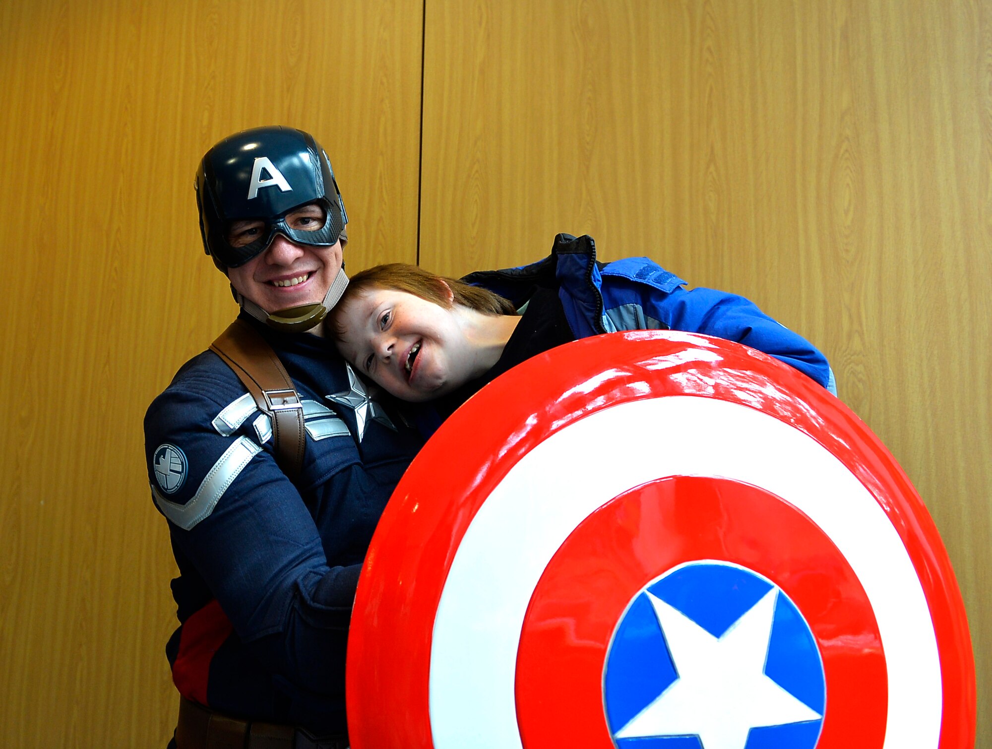 Captain America poses for a picture with a student during the 2016 Winter Special Olympics at Vogelweh Military Complex, Germany, Dec. 2, 2016. Activities from the event included bowling and arts and crafts, with visits from Captain America and Santa Claus. (U.S. Air Force photo by Airman 1st Class Joshua Magbanua)