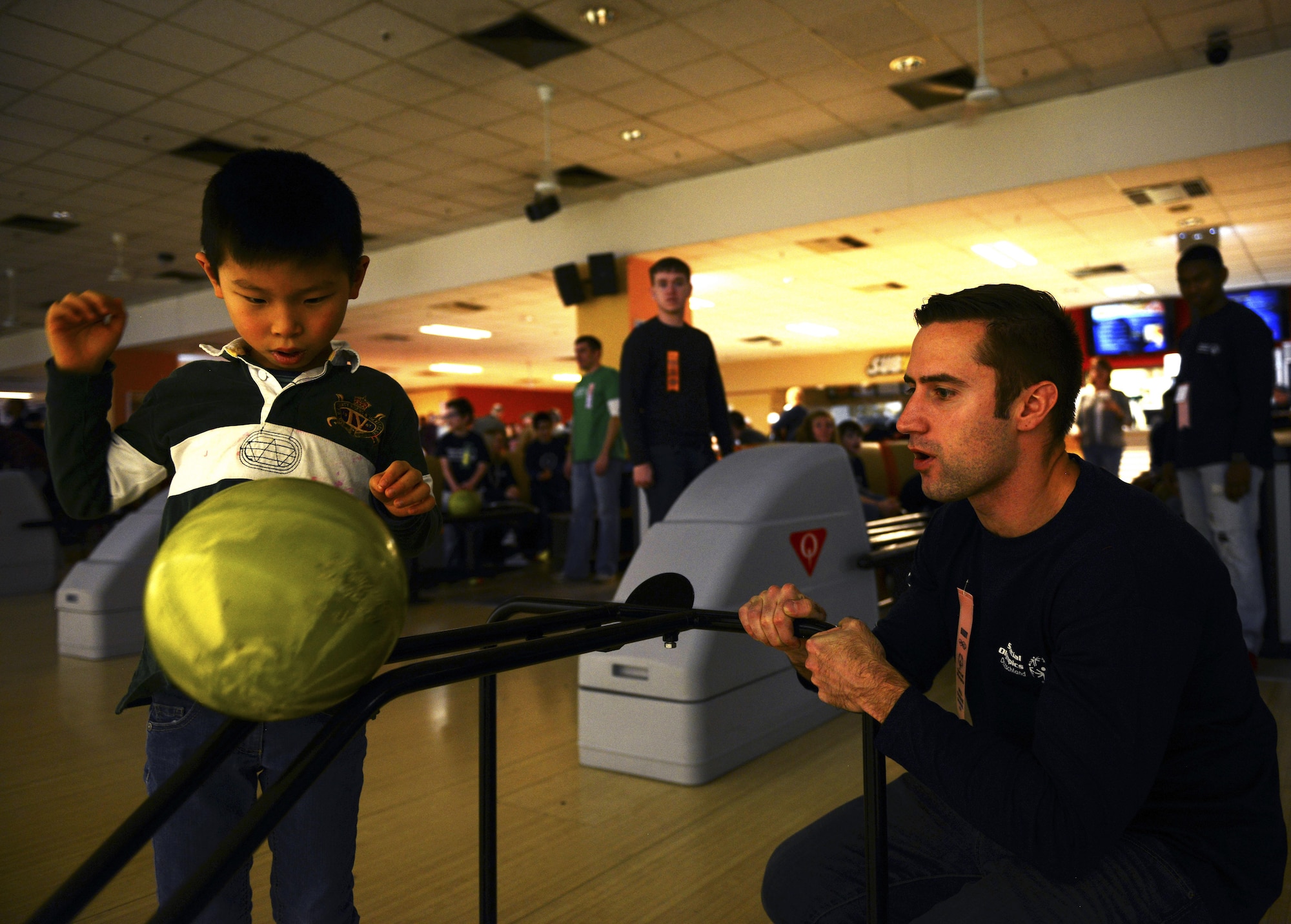 A Special Olympics volunteer, right, assists a participant in bowling at the Vogelweh Military Complex, Germany, Dec. 2, 2016. Volunteers from around the Kaiserslautern Military Community gather at the event to help special needs children enhance their social skills and boost their self-confidence. (U.S. Air Force photo by Airman 1st Class Joshua Magbanua)