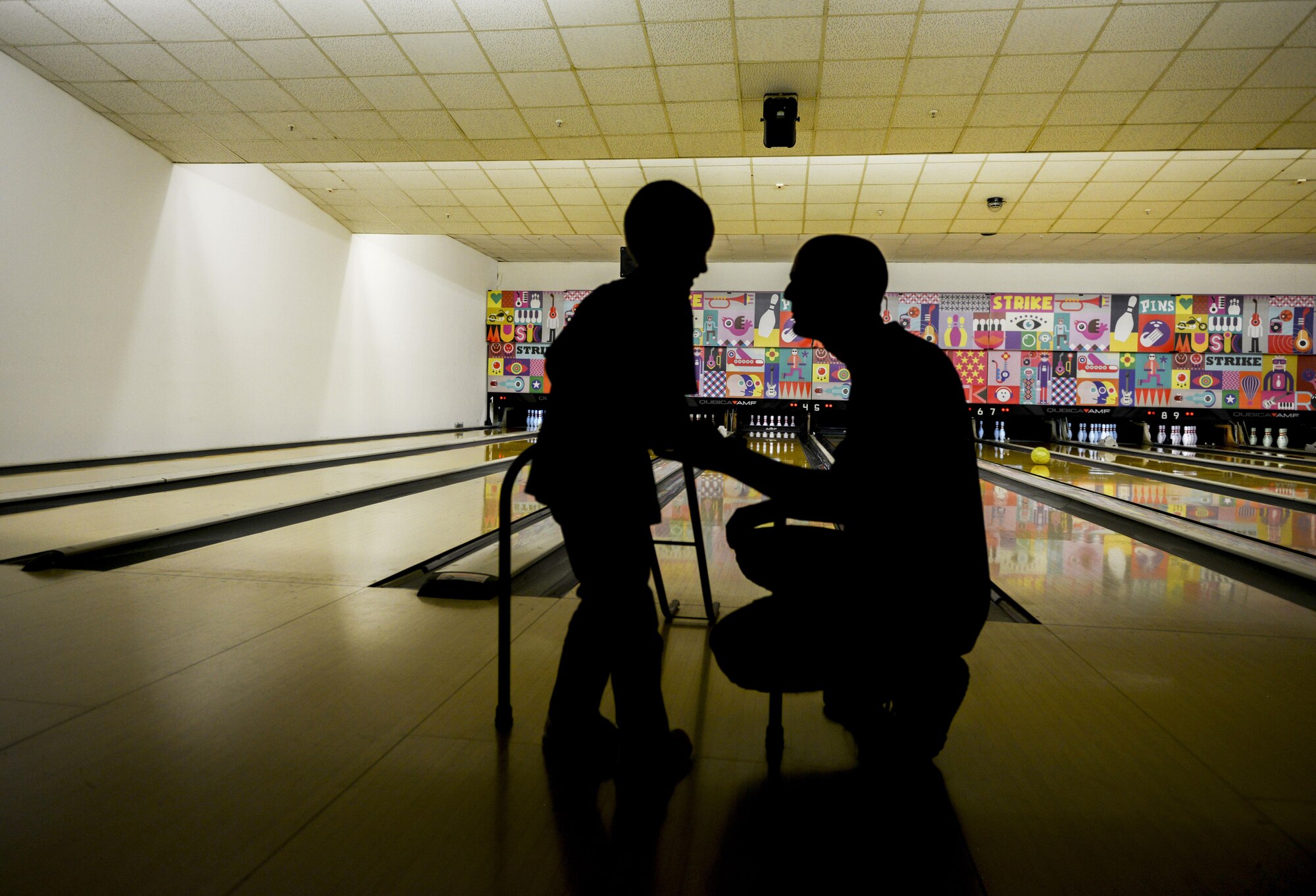 Senior Airman Alexander Truskowski, 86th Vehicle Readiness Squadron vehicle maintenance journeyman, assists a Special Olympics participant during a game of bowling at Vogelweh Military Complex, Germany, Dec. 2, 2016. The event aimed to give special needs children a chance at participating in modified sports and enhance their social interaction skills. 