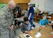 U.S. Air Force Col. Todd Hohn, 97th Air Mobility Wing commander, watches as students play with learning materials, December 6, 2016, Altus Air Force Base, Oklahoma. The STEM initiative hopes to inspire the next generation to take an interest in science, technology, engineering and mathematics. (U.S. Air Force Photo by Airman Jackson N. Haddon/Released).