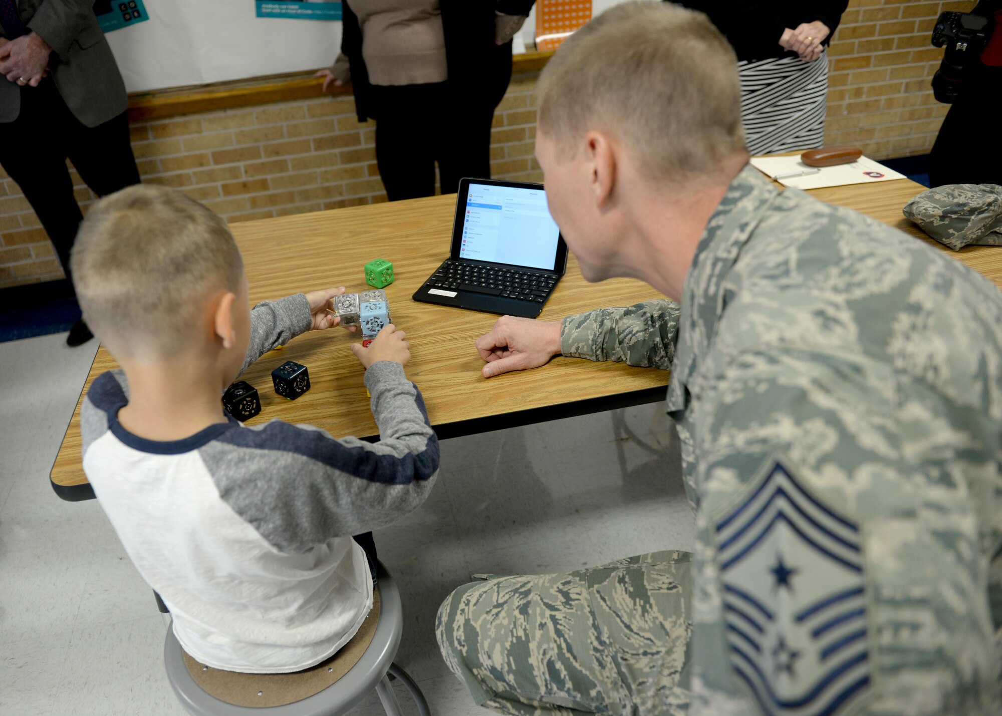 U.S. Air Force Chief Master Sgt. Phillip Eckenrod, 97th Air Mobility Wing command chief, observes children playing with scientific learning materials, December 6, 2016, Altus Air Force Base, Oklahoma. The STEM initiative hopes to inspire the next generation to take an interest in science, technology, engineering and mathematics. (U.S. Air Force Photo by Airman Jackson N. Haddon/Released).