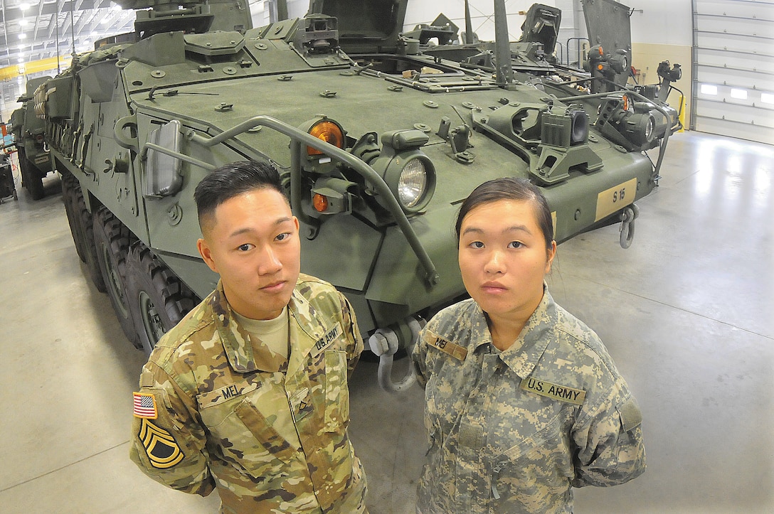 Army Pfc. Sam and Pvt. Jennifer Mei, both Pennsylvania Army National Guardsmen, pose in front of a Stryker armored fighting vehicle at the Ordnance School at Fort Lee, Va., Nov. 17, 2016. Sam graduated from the 17-week course Nov. 22, while Jennifer is scheduled to complete the course in March. Another sibling, 19-year-old Milton, is also undergoing training at Fort Lee as a student in the Petroleum Supply Specialist Course taught by the Quartermaster School. Army photo by Terrance Bell