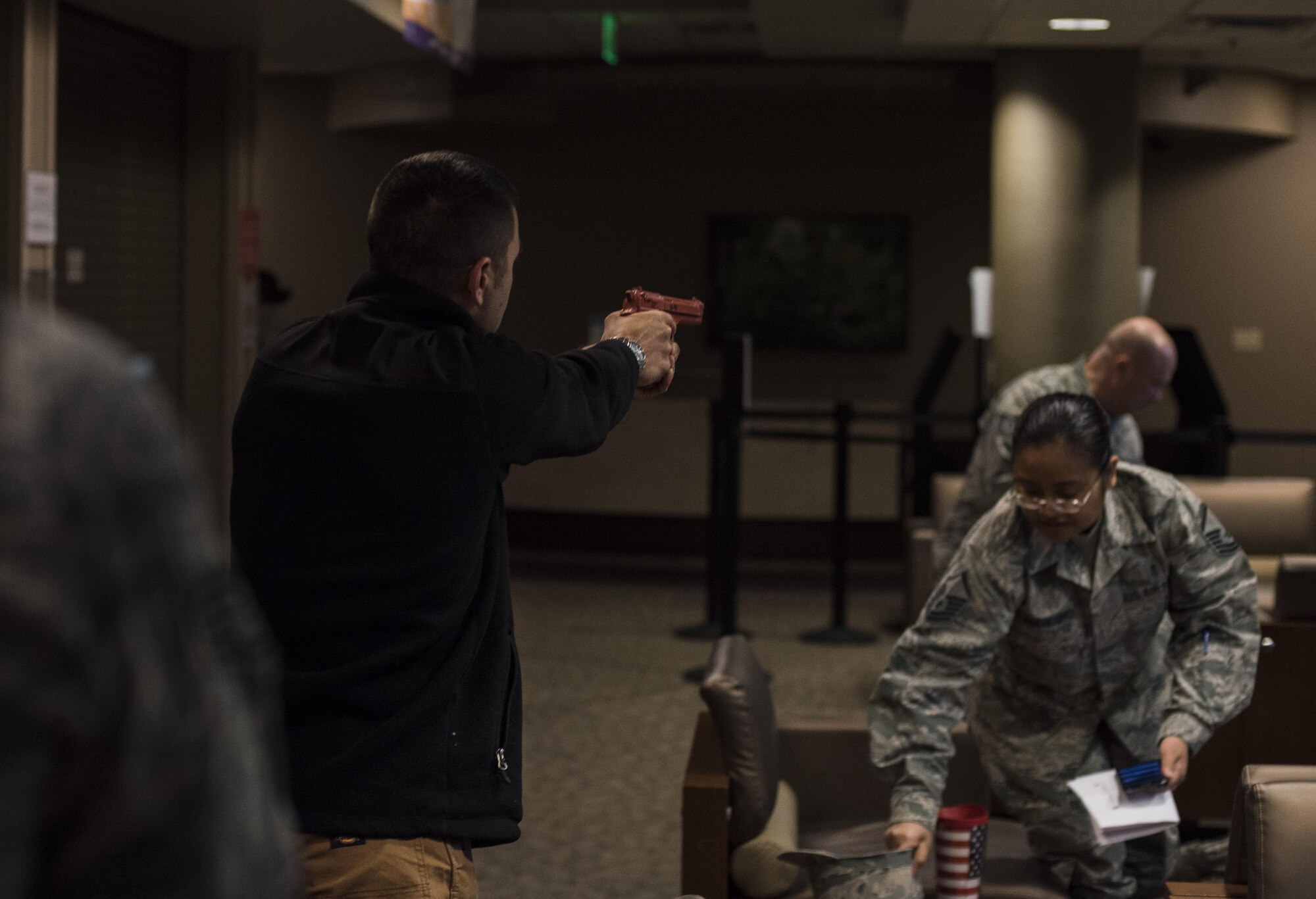 Master Sgt. Jeremy Utphall, 2nd Bomb Wing Inspector General exercise division superintendent, aims a training weapon at Airmen during an active shooter exercise at Barksdale Air Force Base, La., Nov. 29, 2016. Like an actual active shooter incident, Airmen weren’t given a warning. While some were caught off guard, others implemented their training and avoided Utphall as he searched the medical building for victimes. (U.S. Air Force photo/Senior Airman Damon Kasberg)