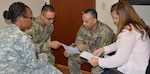 (From left) Staff Sgt. Karolyn King, squad leader; Staff Sgt. Ron Jimenez, platoon sergeant; and Olga Ledford, nurse case manager, meet with Sgt. 1st Class Joe Rincon Dec. 1 at the Warrior Transition Battalion at Joint Base San Antonio-Fort Sam Houston. Triad of Care team members frequently meet with their Soldiers to discuss things like appointment schedules.