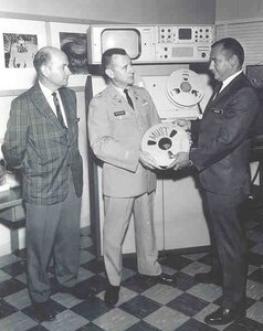 In 1967, one of MFSS-TV’s first productions, a one-hour program on the Medical Unit Self-Contained Transportable, or MUST, was produced alongside the Army Photographic Agency Unit over the course of six days for the cost of $1,500. At the time, a typical instructional motion picture of its length would have taken at least three months and an average of $75,000 to produce.  Lt. Col. Stephen P. Dittman (center), the first MFSS-TV chief, is holding the video reel.