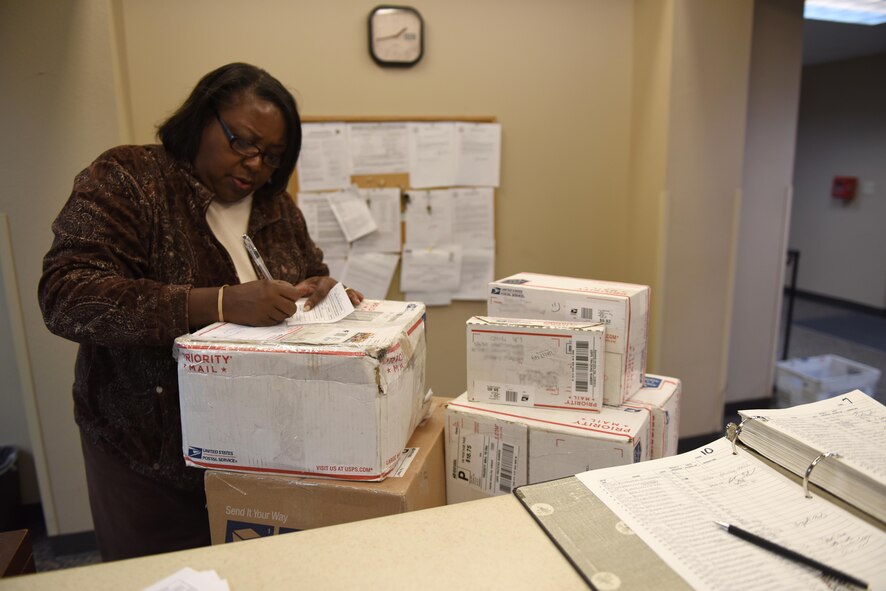 Sharron Jackson, 2nd Communications Squadron contract site manager, fills out a mail pickup notice so dorm Airmen can collect their packages at Barksdale Air Force Base, La., Dec. 7, 2016. Postal service center employees place a package slip in an Airman’s postal box to inform them they have mail. (U.S. Air Force photo/Airman 1st Class Alexis C. Schultz)