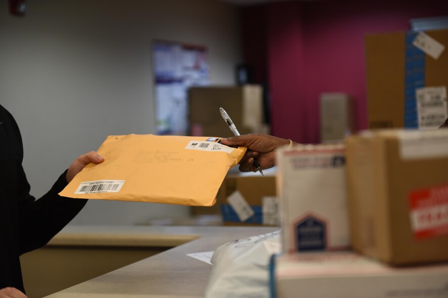 An Airman picks up a package at Barksdale Air Force Base, La., Dec. 7, 2016. The postal service center requires picture identification and signature from anyone retrieving a package to verify the owner has received their property. (U.S. Air Force photo/Airman 1st Class Alexis C. Schultz)
