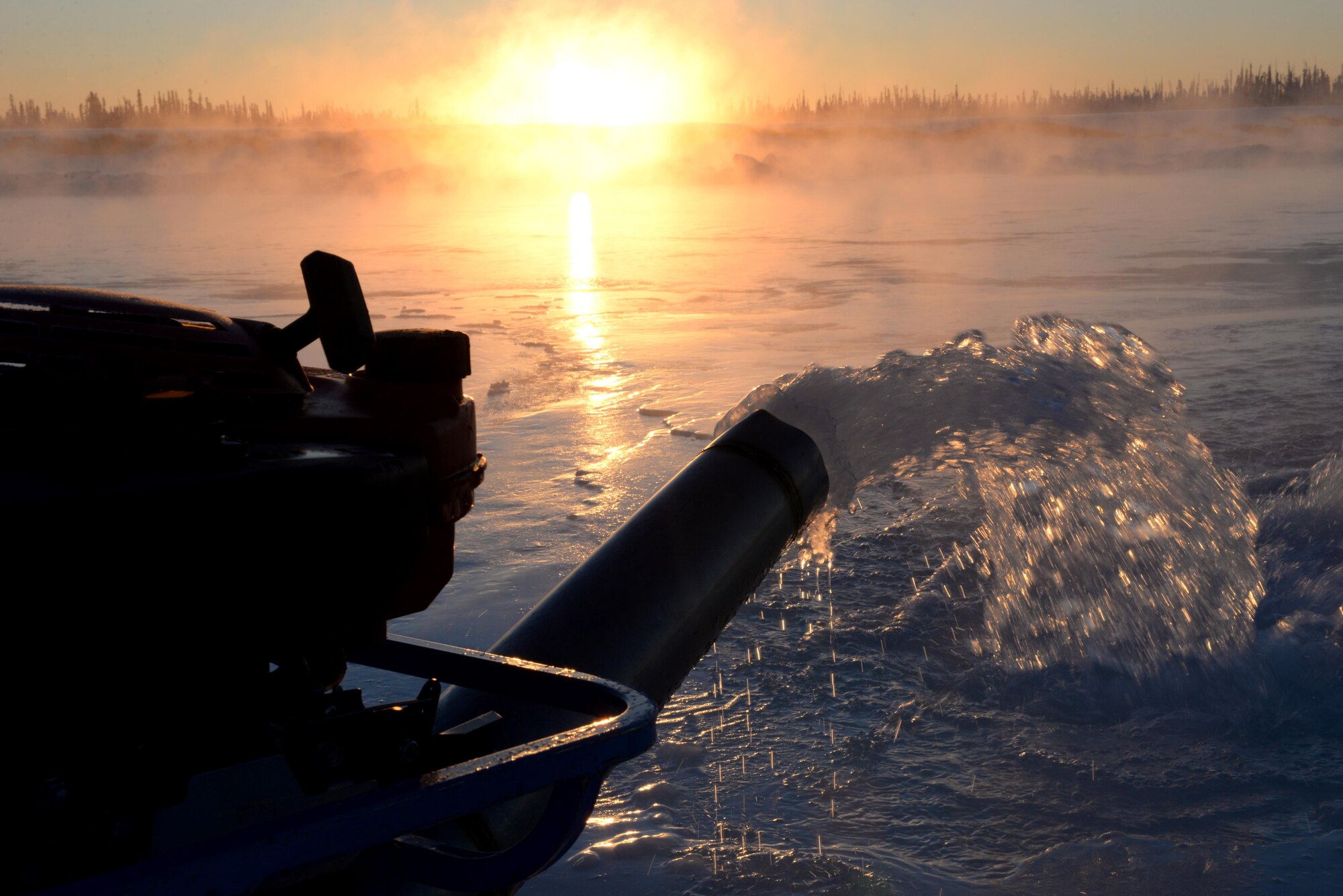 A water pump belonging to the 354th Civil Engineer Squadron was placed through ice on the Tanana River Dec. 5, 2016, in Fairbanks, Alaska. The pump is put into a hole in the ice to force water to the surface and create a smooth path for vehicles. (U.S. Air Force photo by Airman 1st Class Cassandra Whitman)