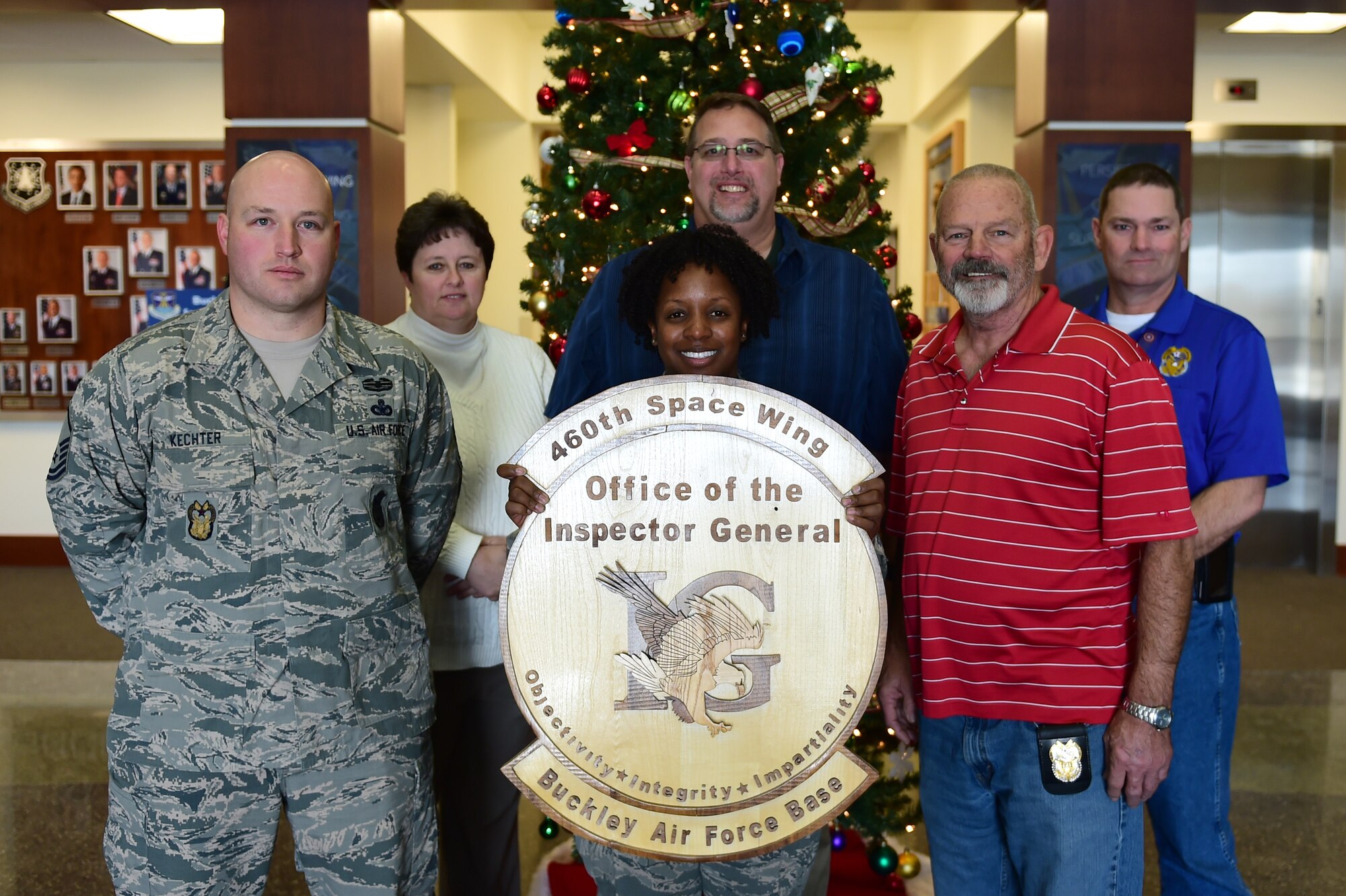 Members of the 460th Space Wing Inspector General office display their shield Dec. 8, 2016, on Buckley Air Force Base, Colo. The IG staff works directly with the commander to ensure the efficiency of the base and the welfare of the Airmen. (U.S. Air Force photo by Airman Jacob Deatherage/Released)