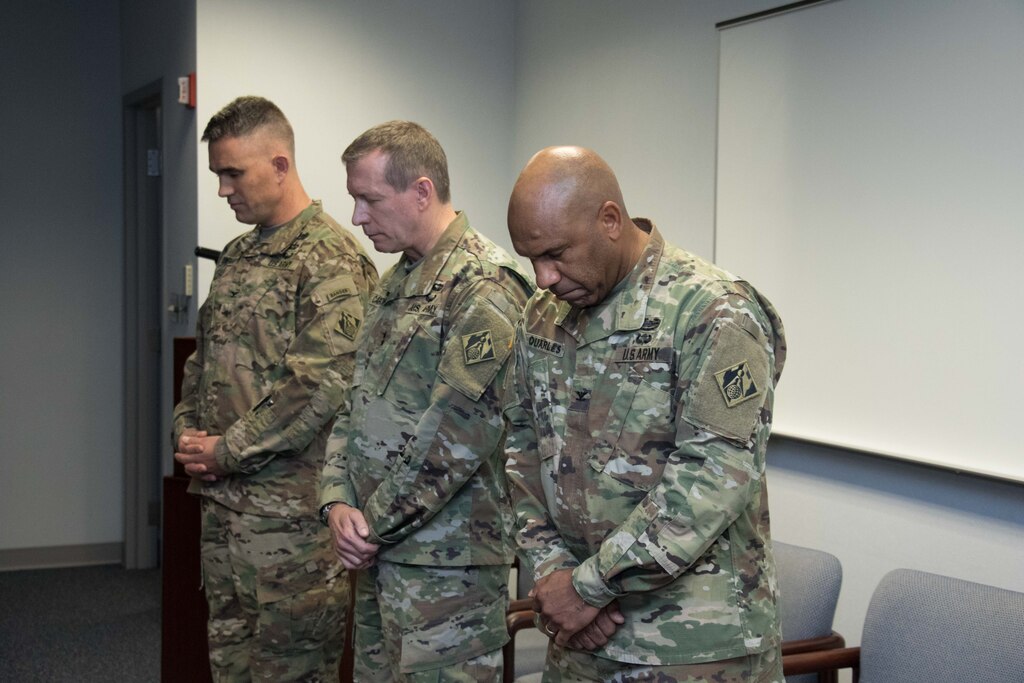 Col. Patrick Kinsman, commander of the U.S. Army Corps of Engineers, Middle East District, Maj. Gen. Robert Carlson, commanding general of USACE Transatlantic Division and Col. Vincent Quarles, outgoing commander of the Middle East District, bow their heads in prayer during the District’s change of command ceremony at MED headquarters in Winchester, Va. Dec. 8.
