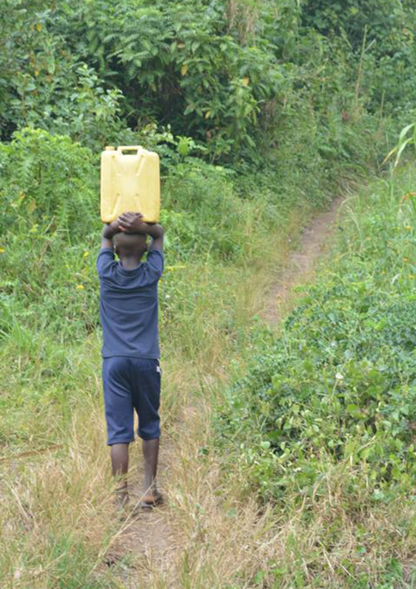 A young boy carries water from a pond to his village. The water contains bacteria that causes illness in villagers. (Courtesy photo)