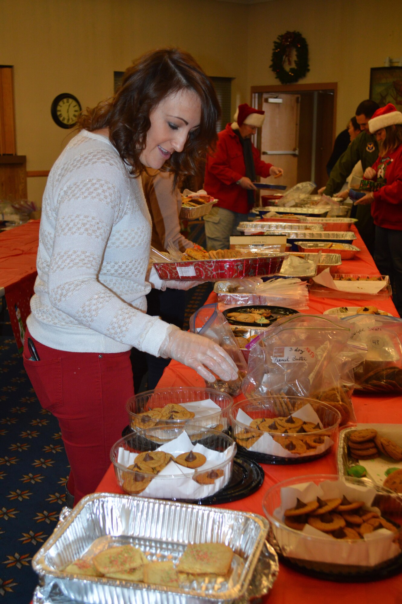 A volunteer prepares a package of cookies for last year's Team Kirtland Airman Cookie Drive. Each year in December, Kirtland Spouses' Club members collect cookies for single Airmen living in the base dorms. They hope to collect 10,000 cookies this year. 