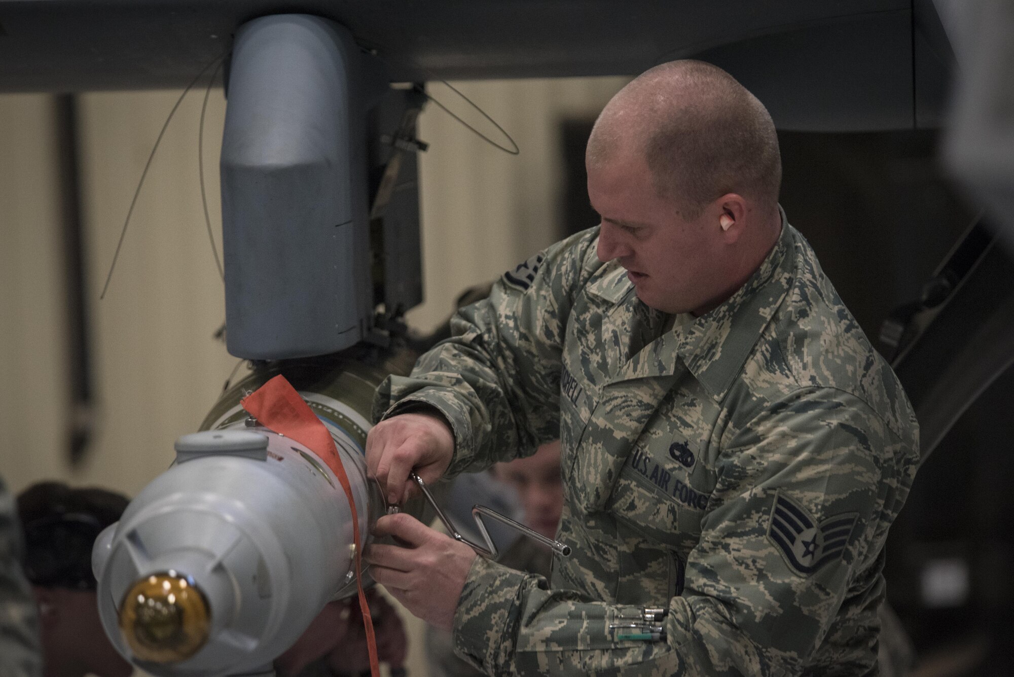 U.S. Air Force Staff Sgt. James Mitchell, 27th Special Operations Maintenance Squadron 3rd Air Mobility Unit weapons load crew team chief, secures an inert weapon into place for a weapons load competition Dec. 2, 2016, at Cannon Air Force Base, N.M. The competition tests weapons load crews’ proficiency, reliability and speed. (U.S. Air Force Photo by Senior Airman Shelby Kay-Fantozzi/released)